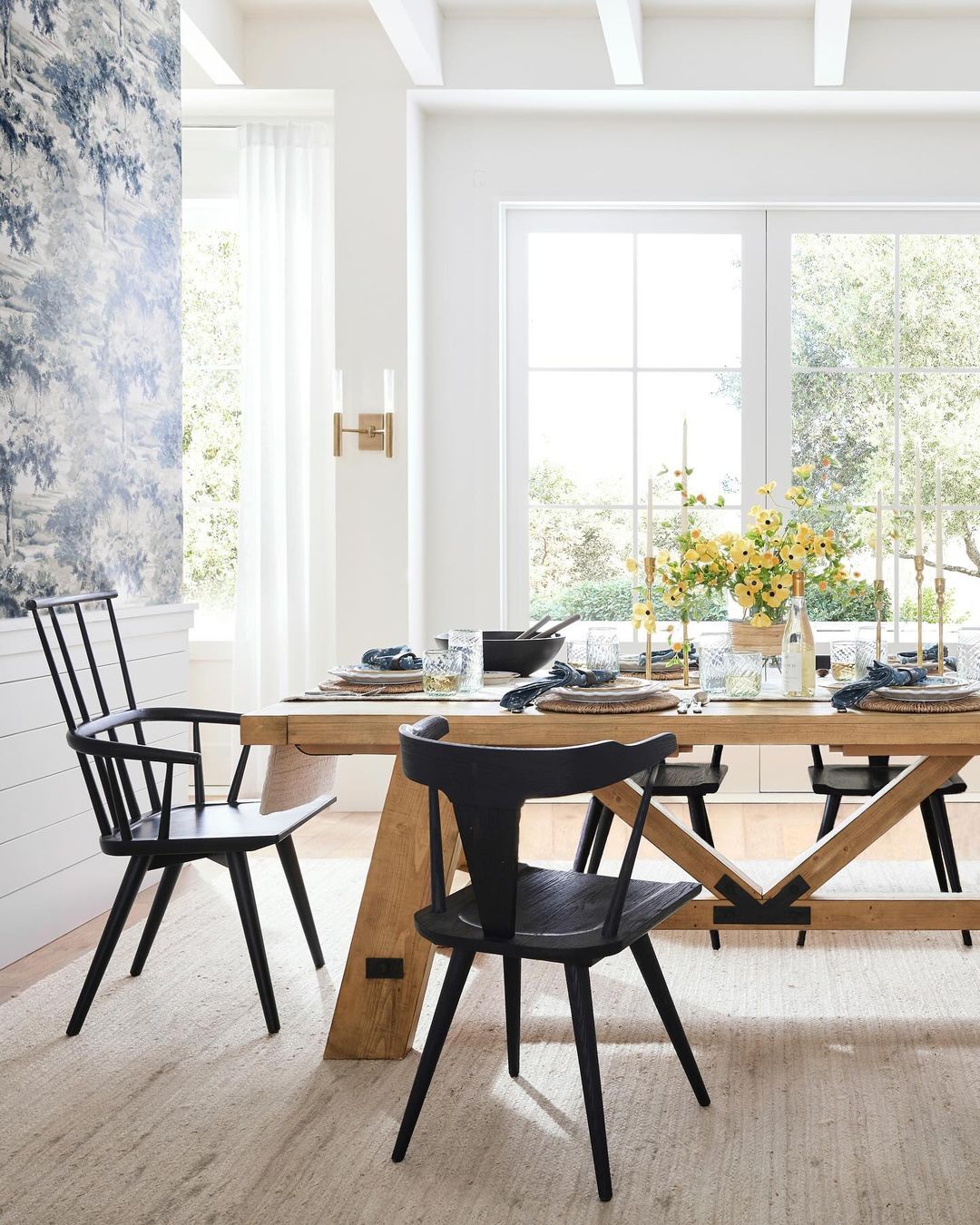 Bright and airy dining room with large windows and a rustic wooden table