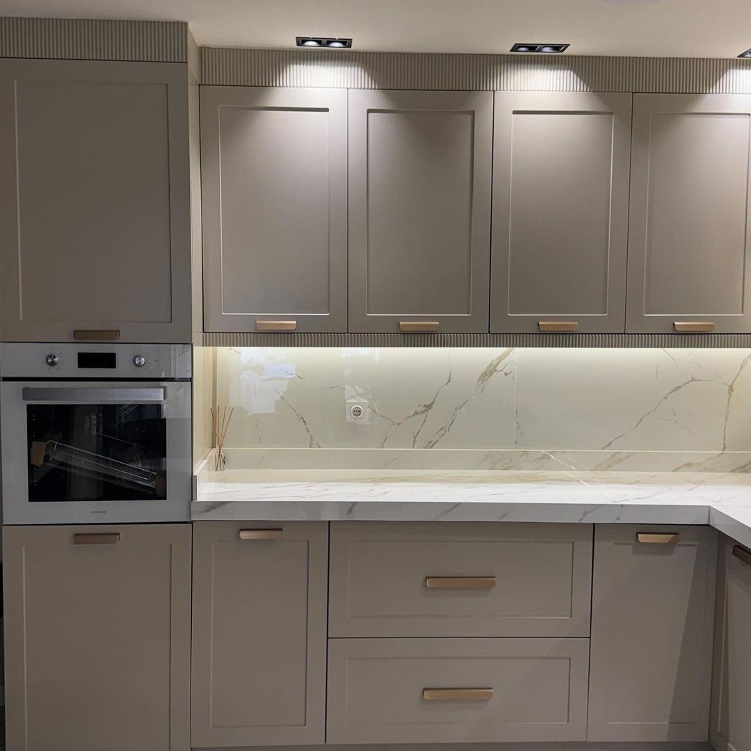 Elegant taupe kitchen featuring a built-in oven and modern fixtures