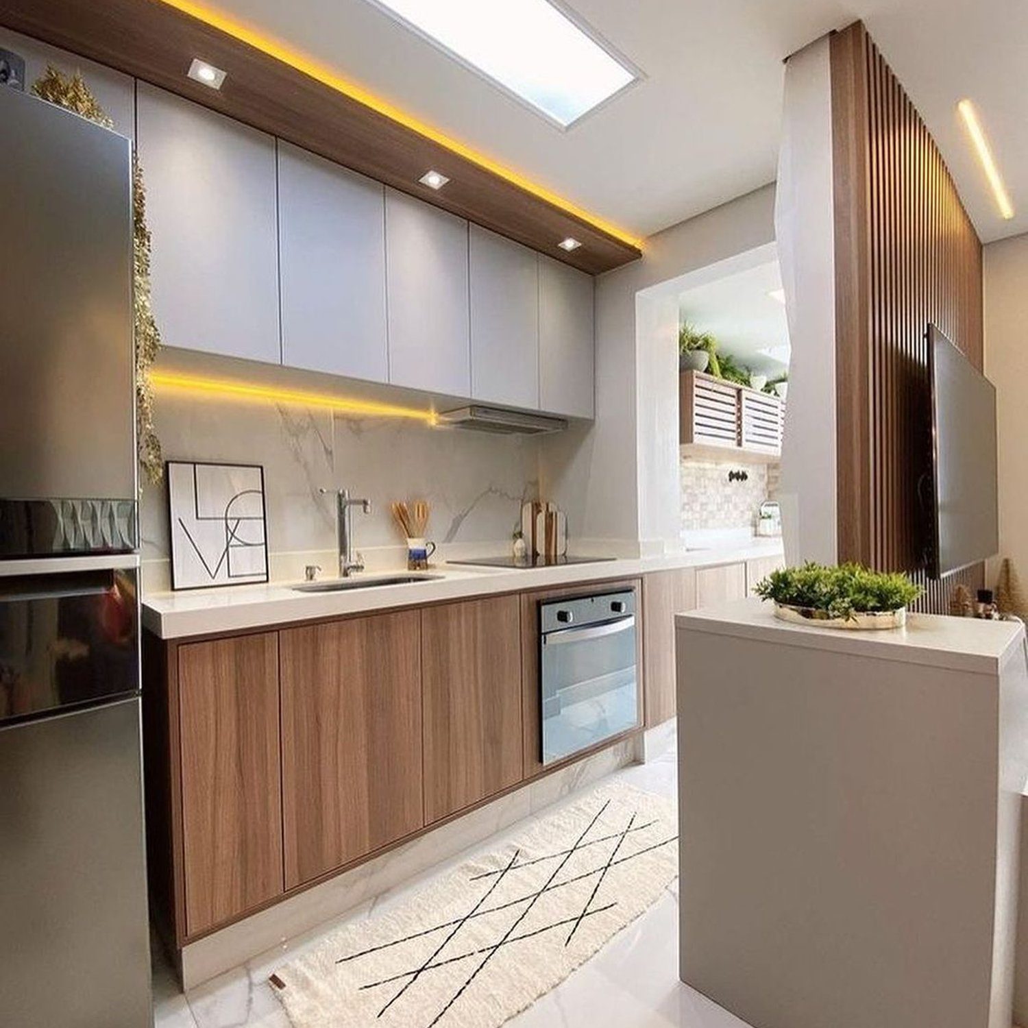 A modern and sleek kitchen with ample lighting and a mix of warm wooden tones and cool grays