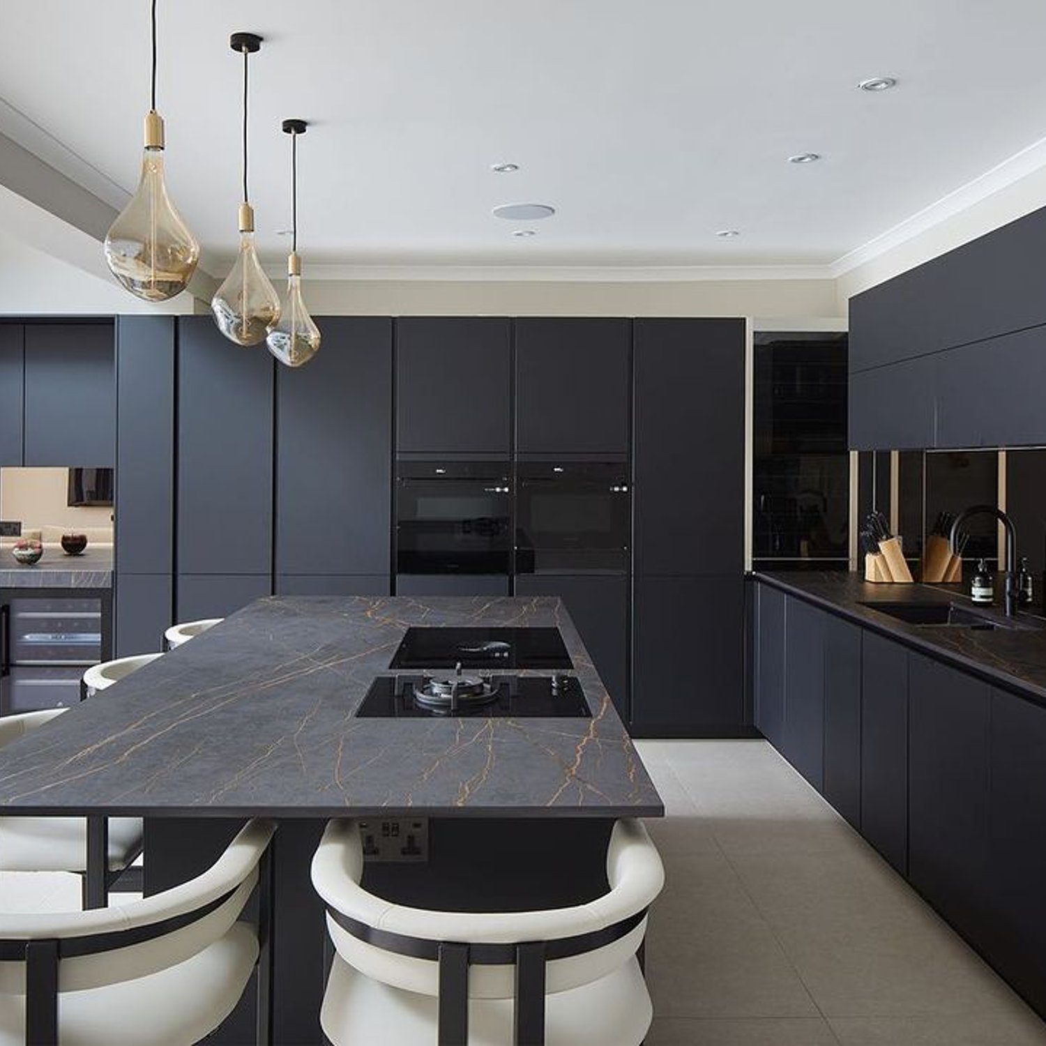 A modern, sleek kitchen featuring matte black cabinetry and a central island