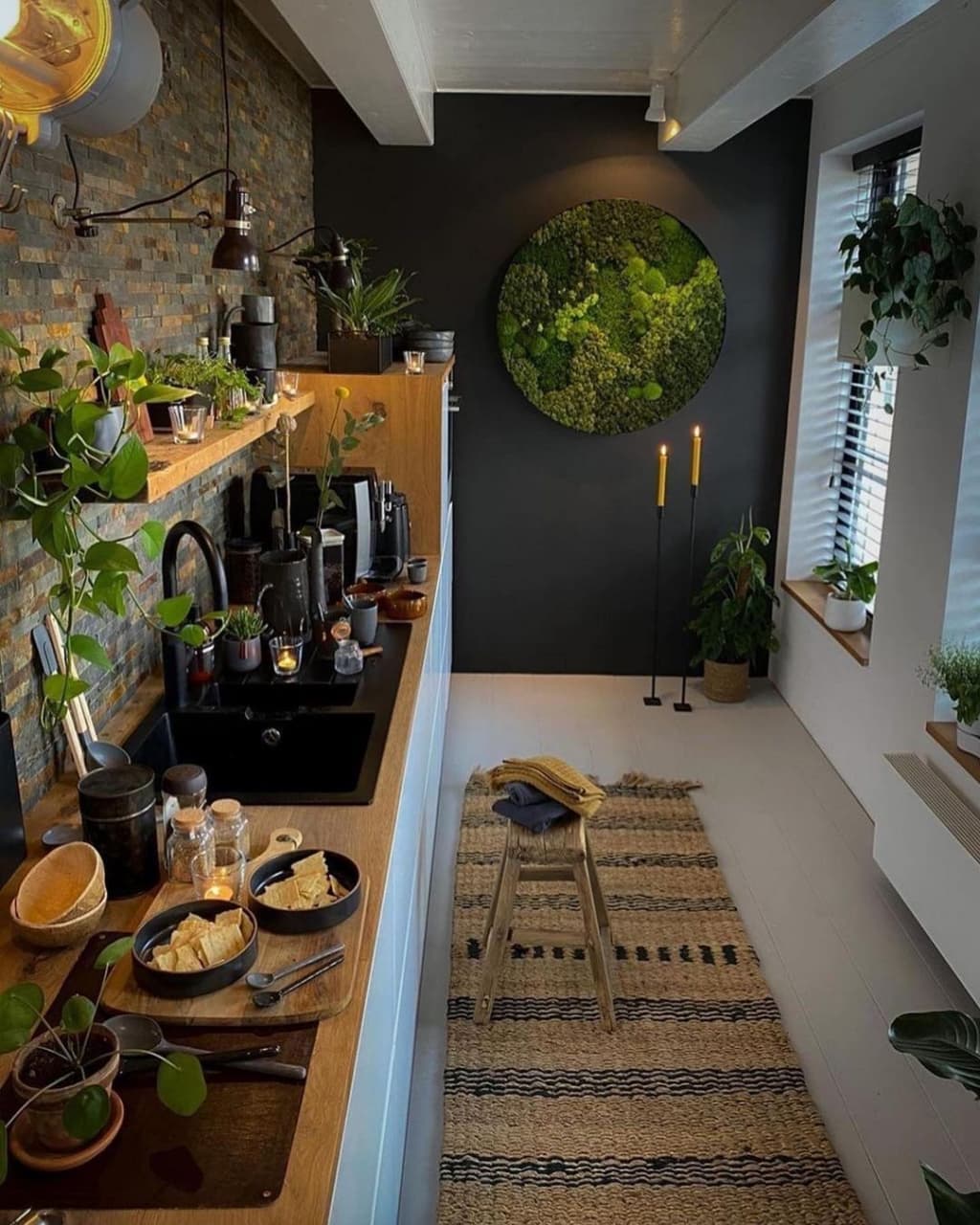 A harmonious blend of nature and design featuring a moss wall art, lush indoor plants, exposed brickwork, and warm wooden accents.