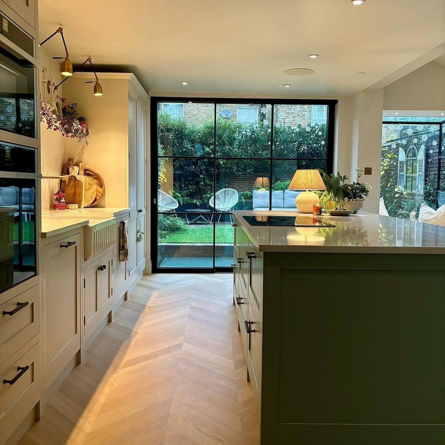 A contemporary kitchen extending to a lush garden through glass doors