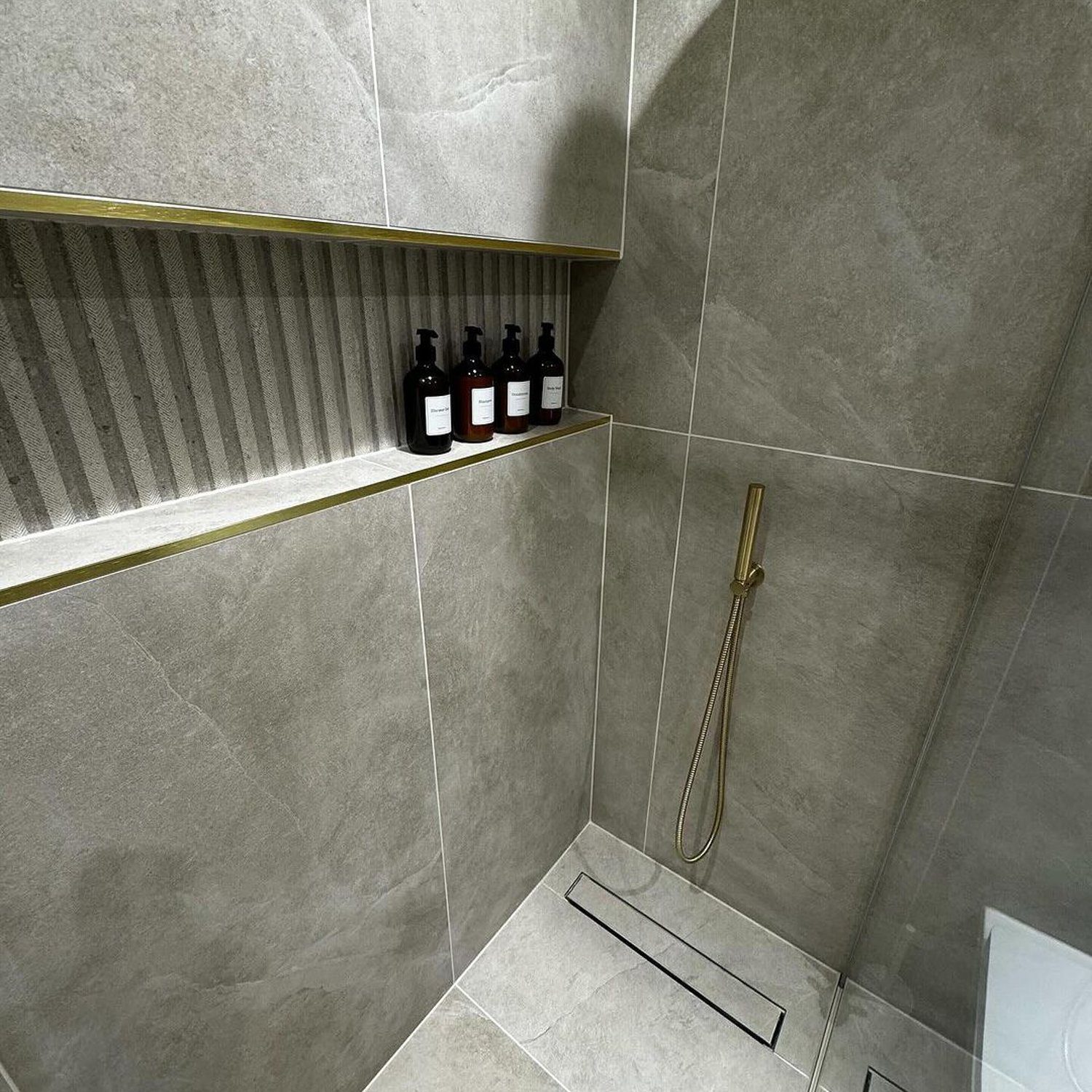 A modern and sleek shower with golden accents