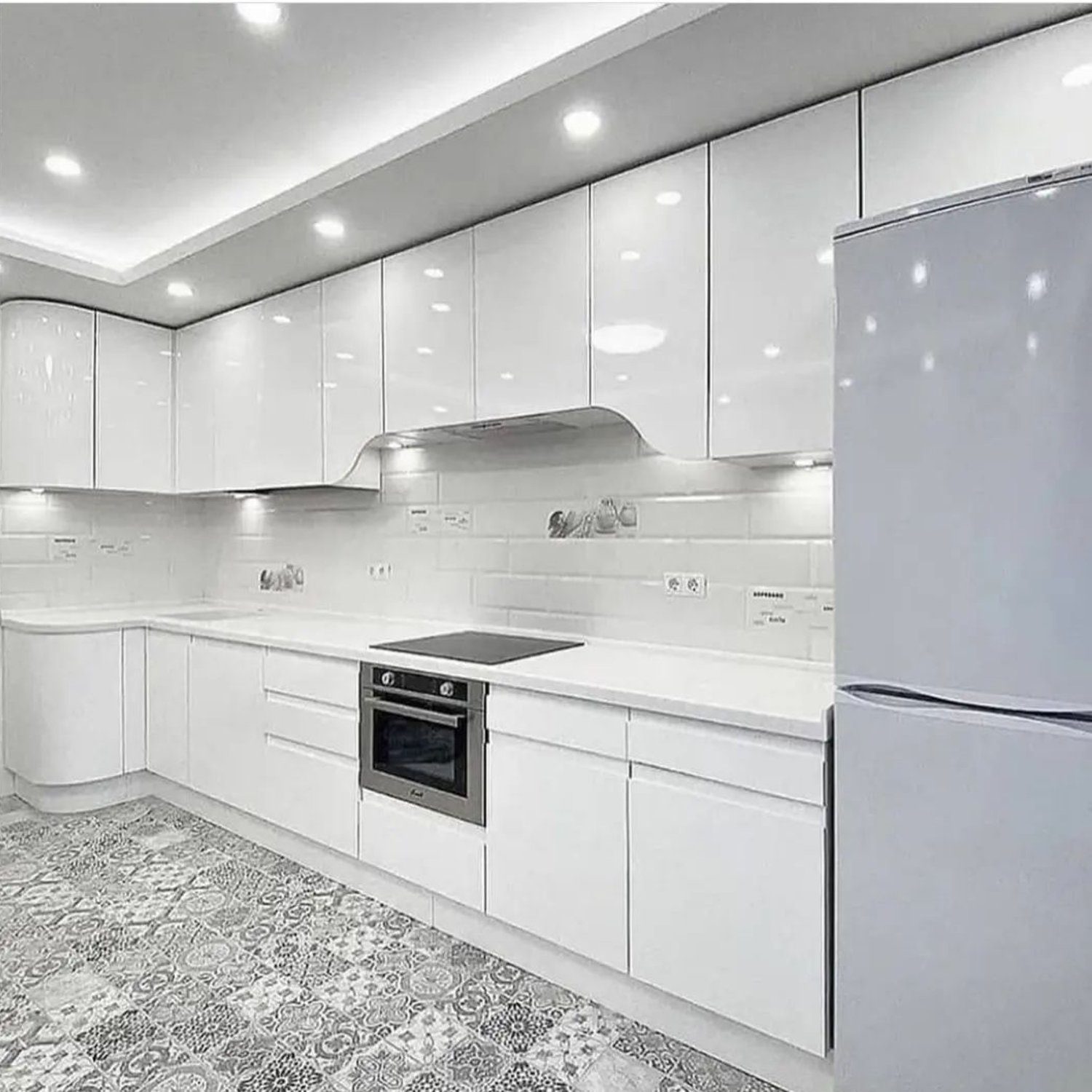 A sleek and modern kitchen with glossy white cabinetry and stainless steel appliances.