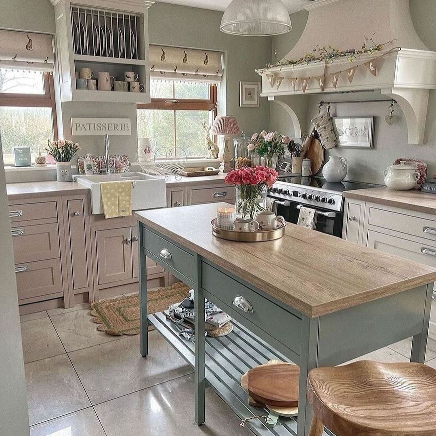 A cozy cottage-style kitchen featuring pastel cabinetry and wooden accents