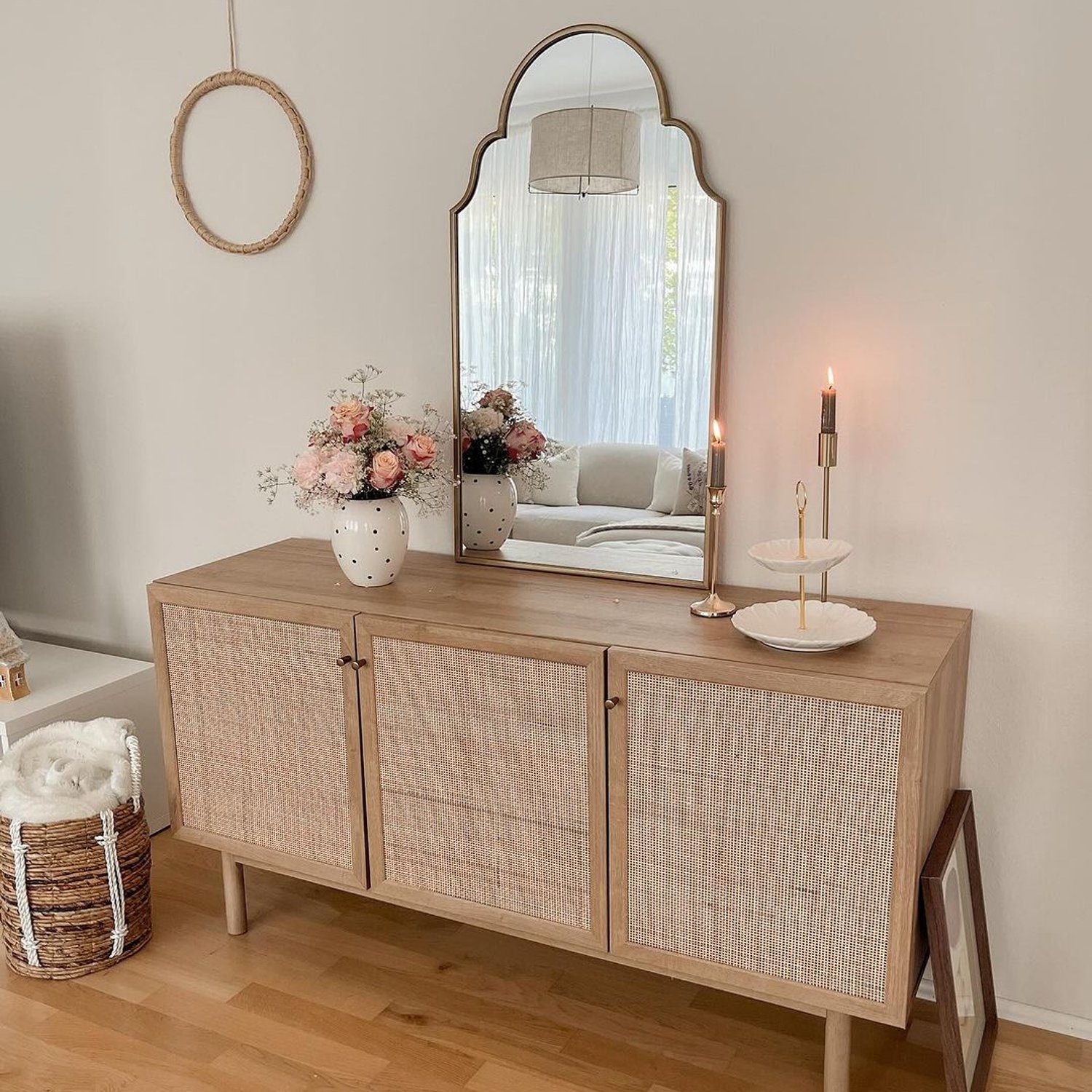 Elegant sideboard setup with a large arched mirror and decorative elements