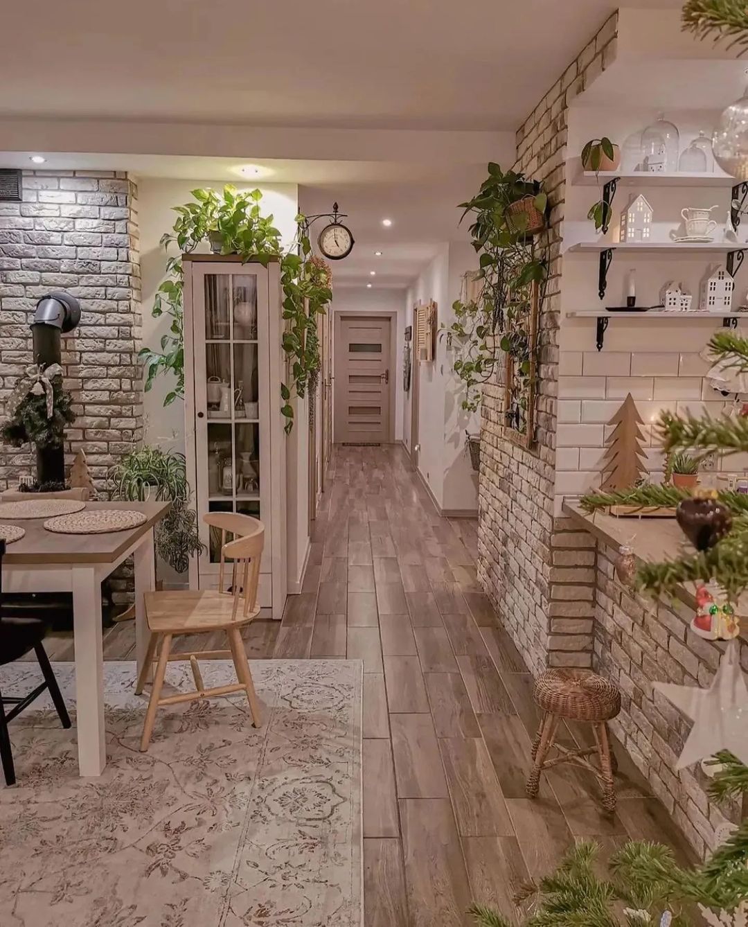 A cozy and inviting interior hallway with brick accents and lush greenery