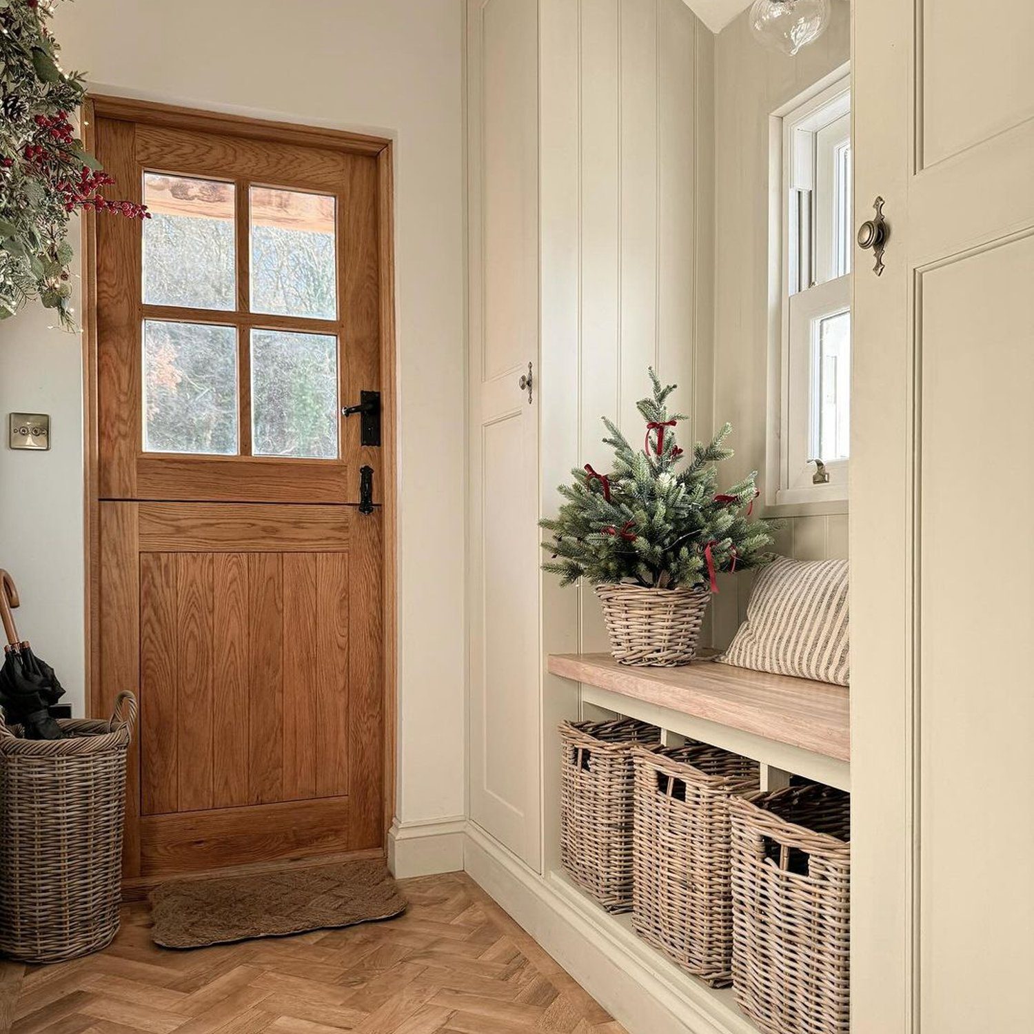 A welcoming entryway featuring a rich, warm wood door and a cozy built-in bench with storage.