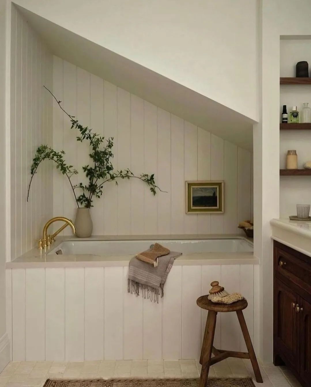 A cozy attic bathroom featuring beige beadboard wainscoting