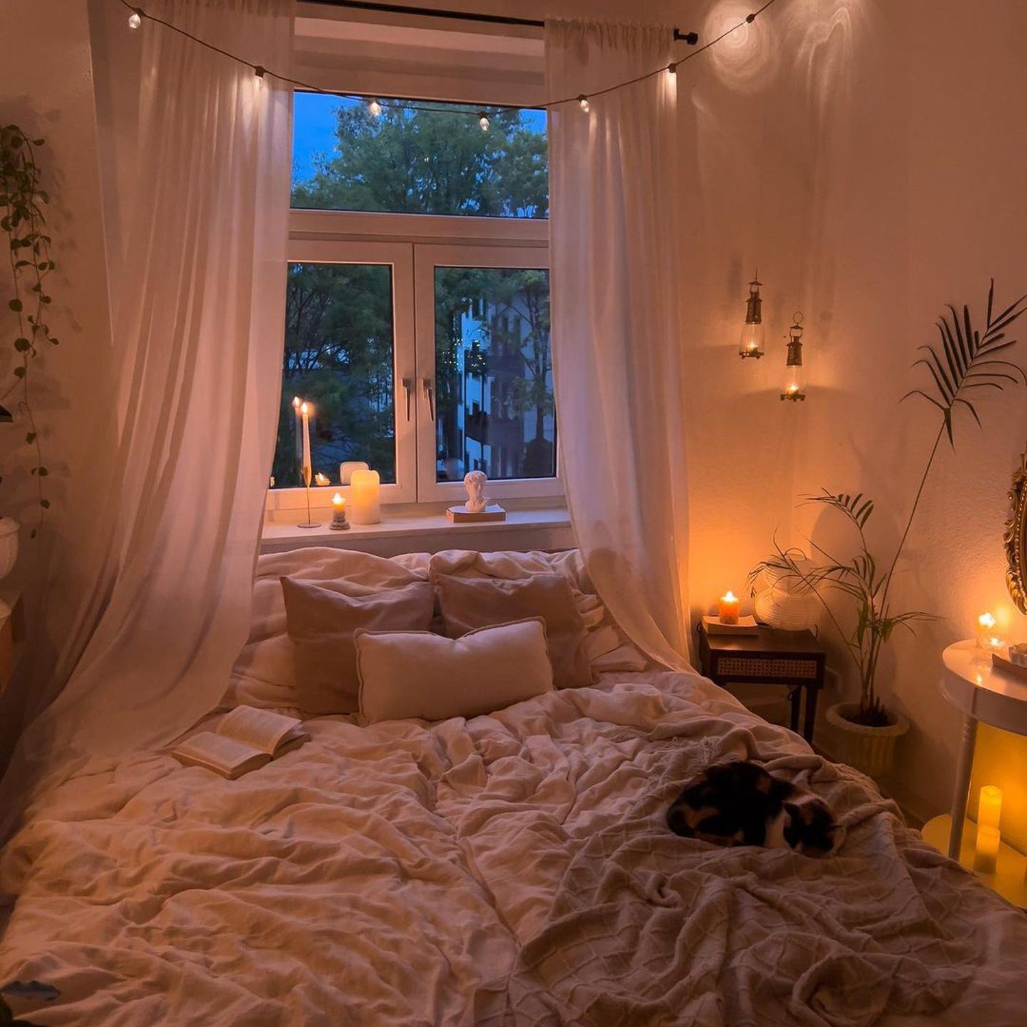 A serene and cozy bedroom with ambient lighting and a resting cat