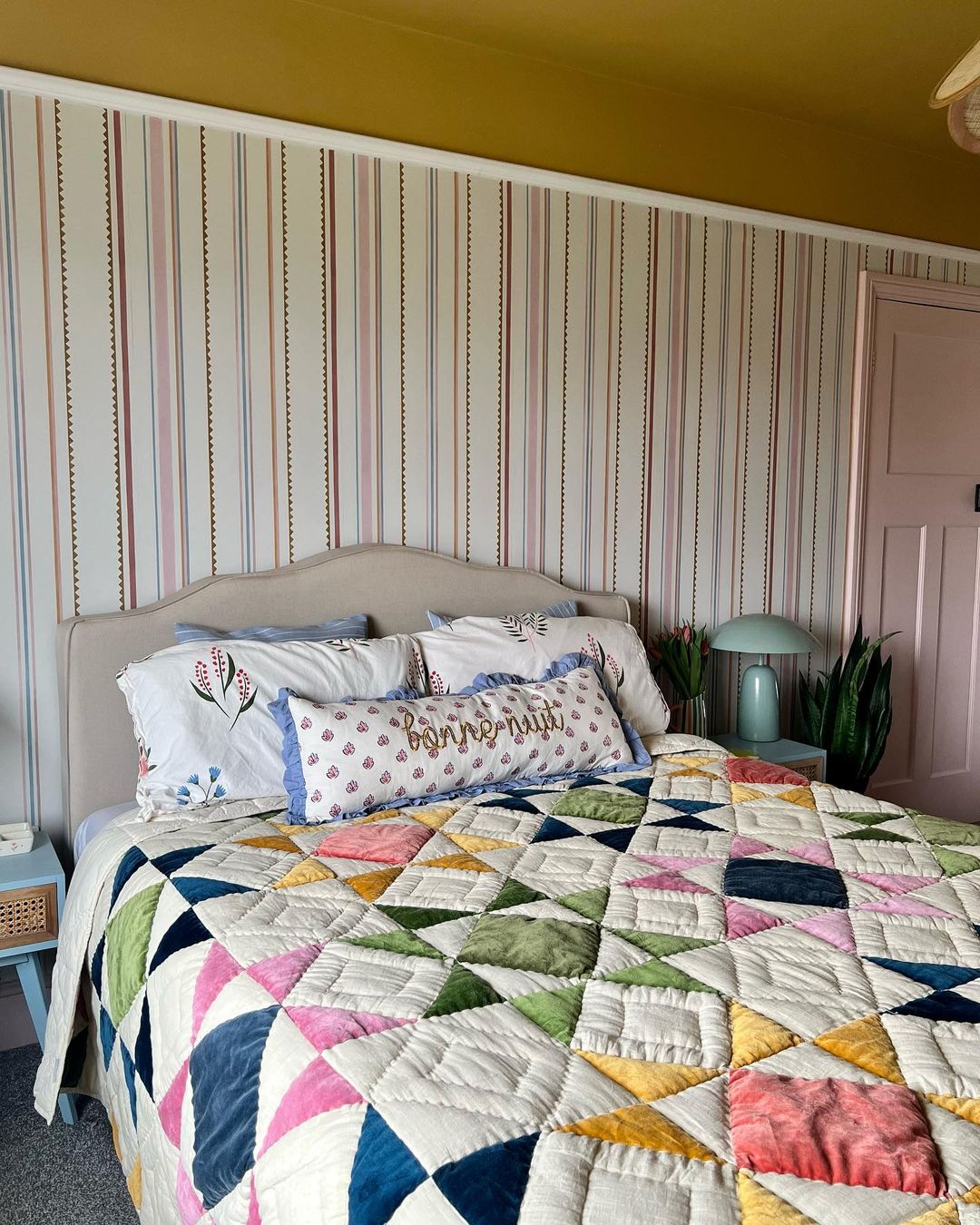 A colorful bedroom with a quilted bedspread