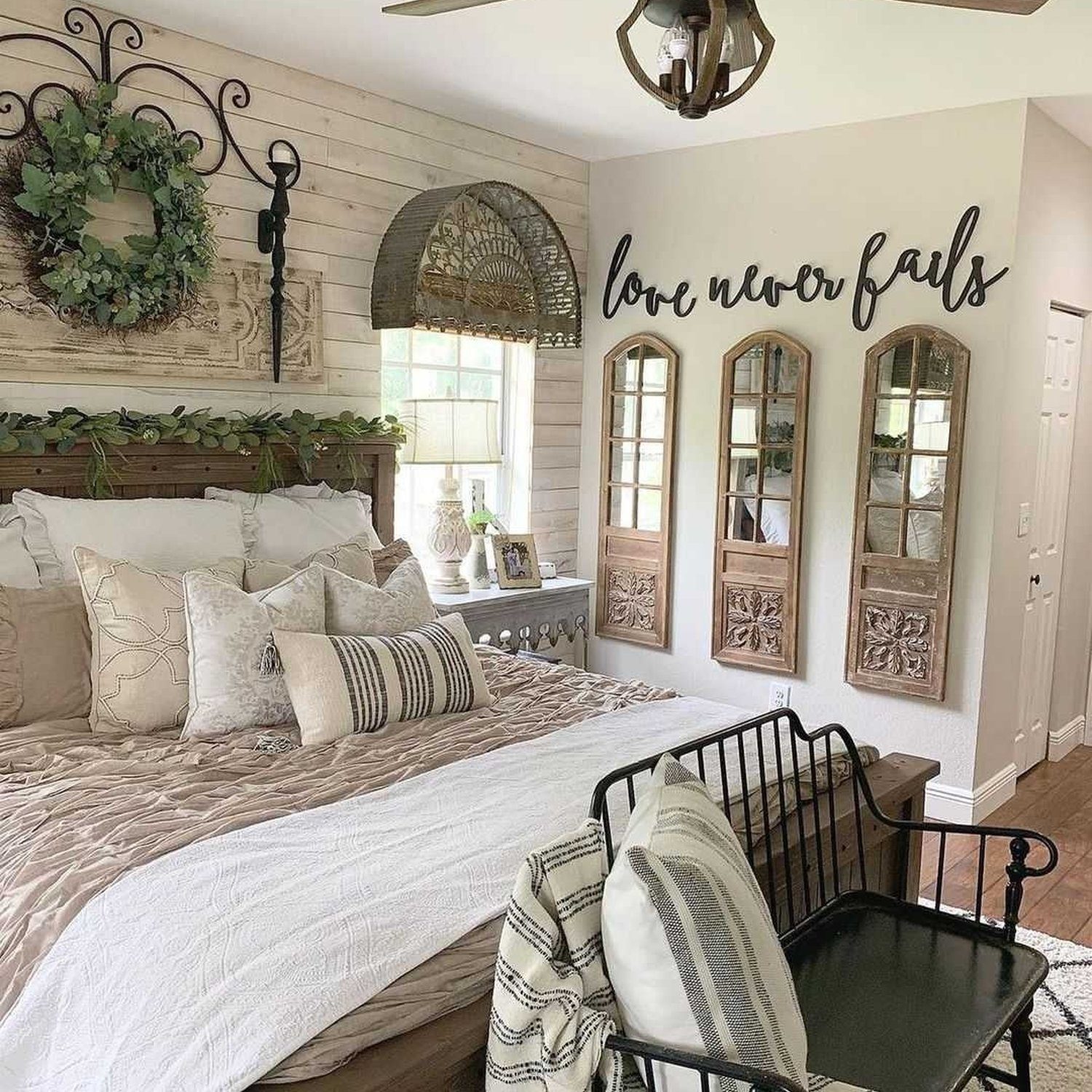 A cozy bedroom featuring shiplap walls, vintage accents and text "love never fails"