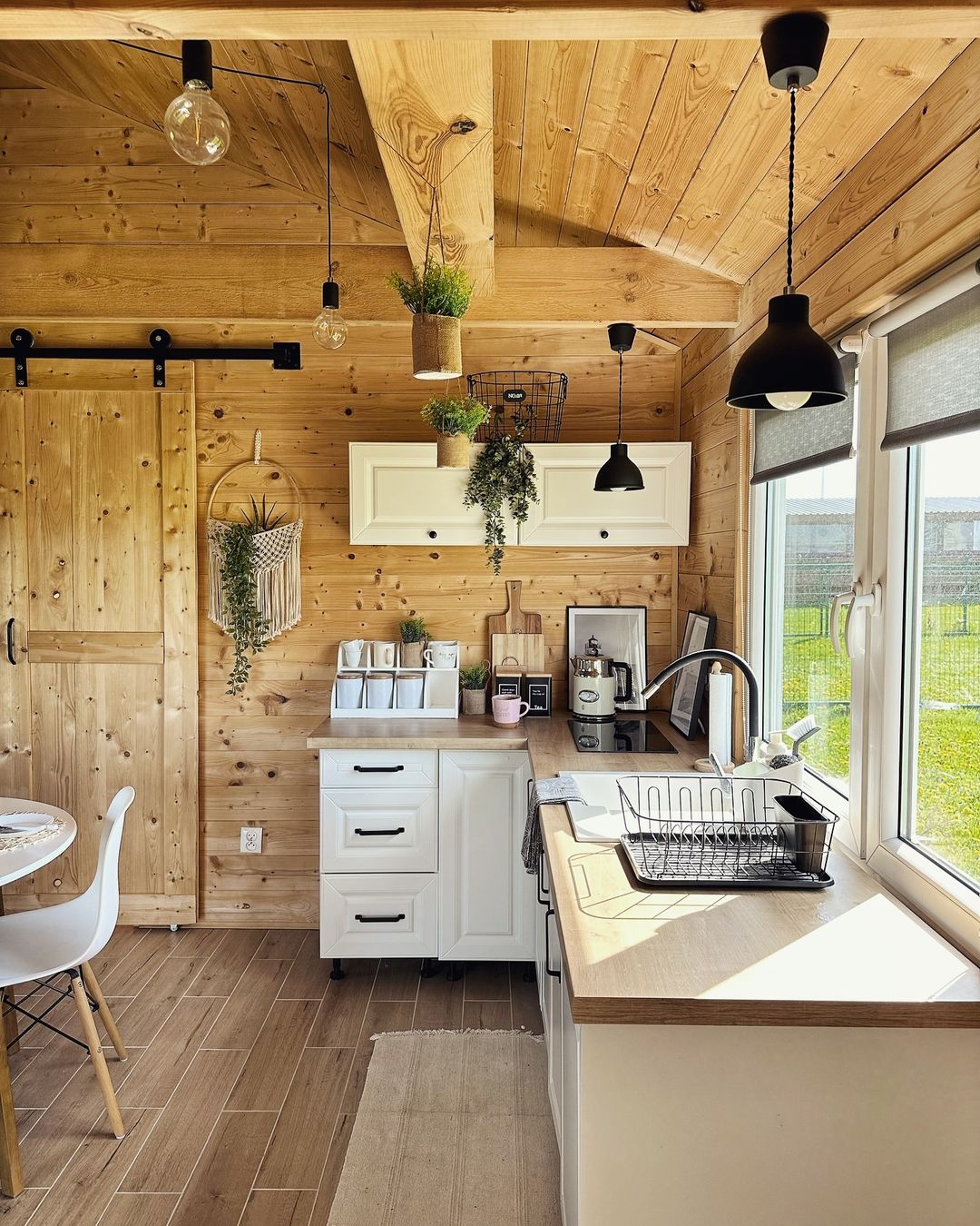 A cozy wooden cabin-style kitchen with modern appliances and charming rustic details.