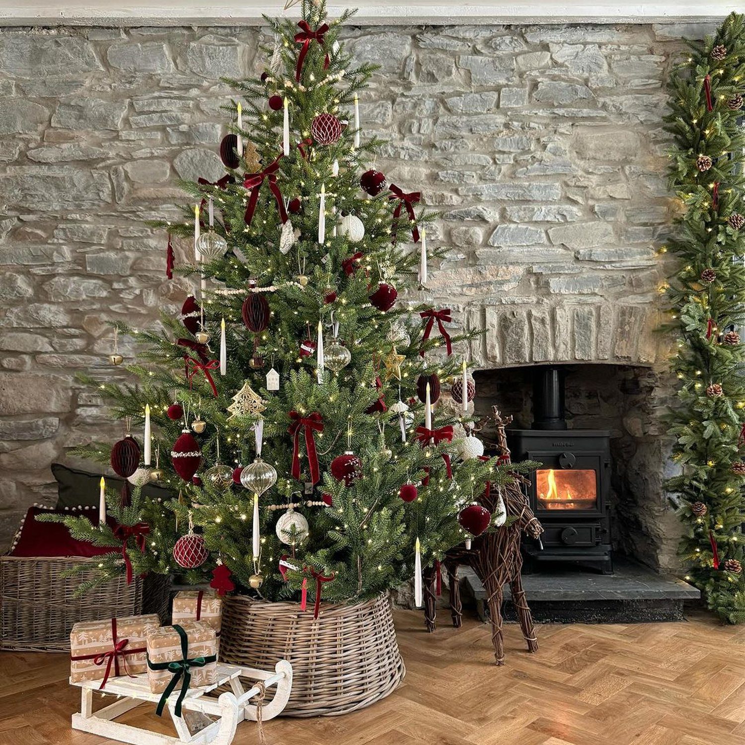 A cozy Christmas setup with a decorated tree and a wood-burning stove