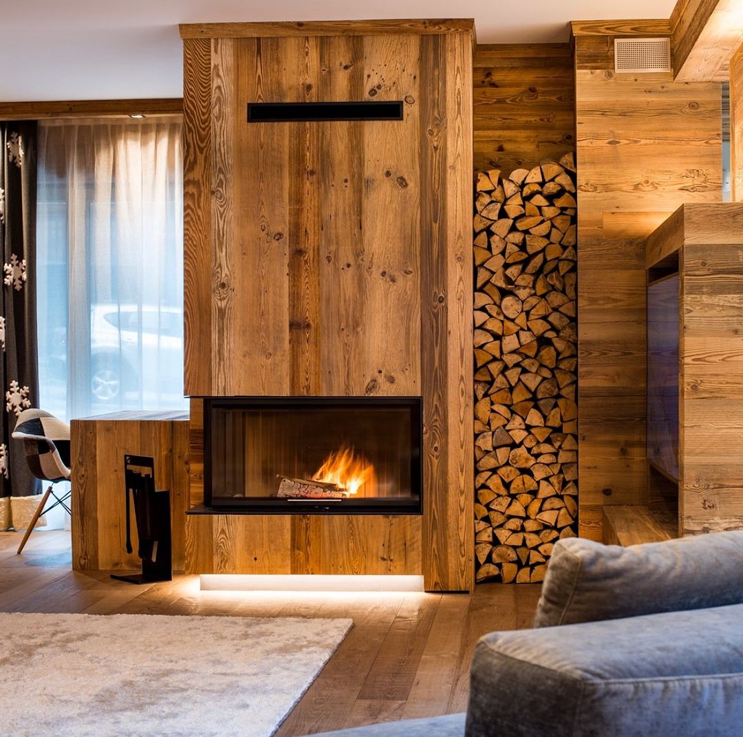 A cozy and warm fireplace setting with stacked firewood