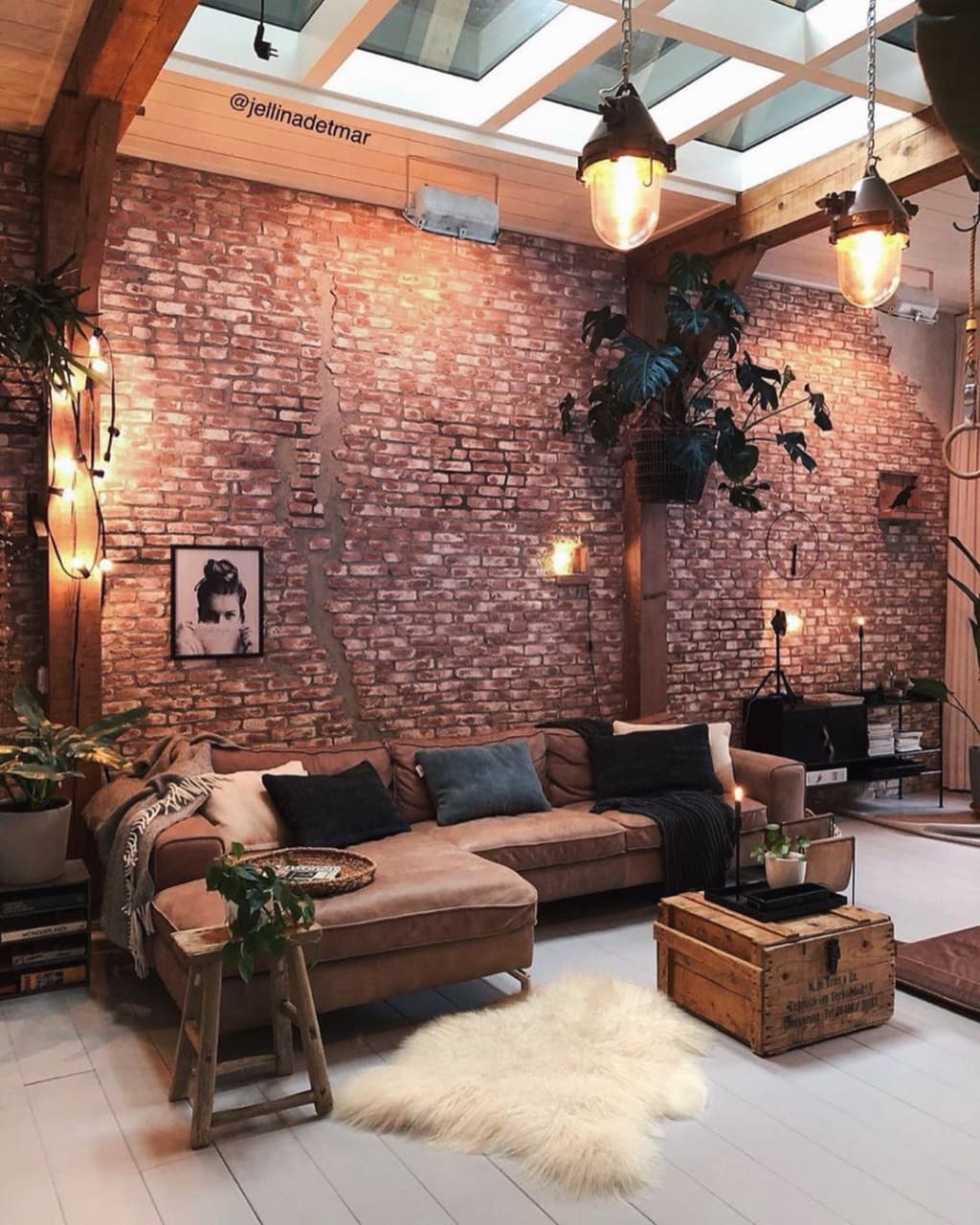 A cozy and inviting industrial living room with exposed brick walls and modern skylights