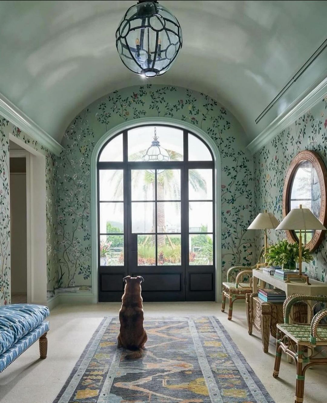 A cozy and inviting interior space featuring a dog looking out a large arched window