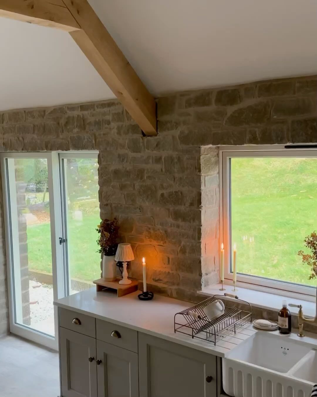 A cozy kitchen corner with exposed stone walls and a large window