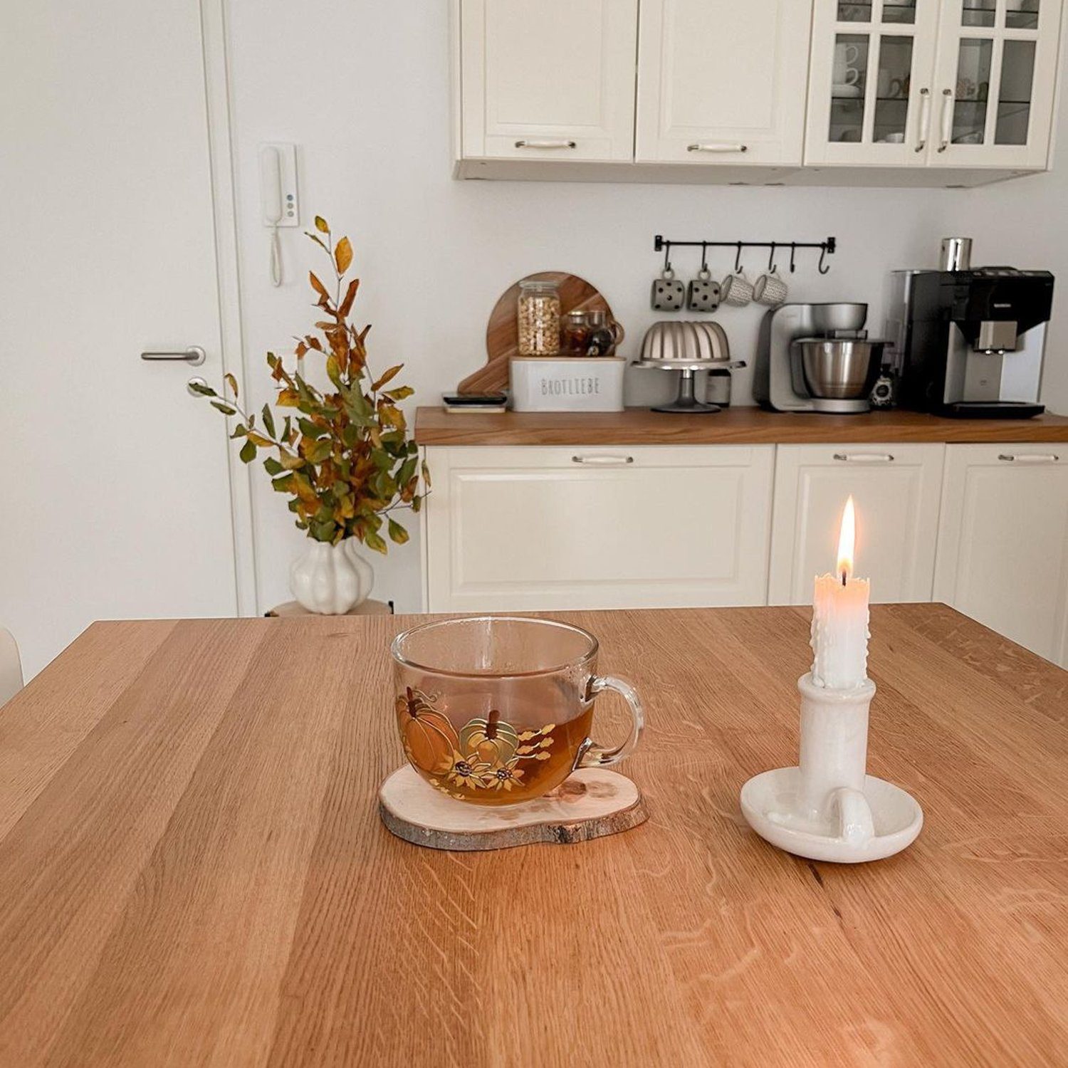 Cozy kitchen setting with a lit candle and a cup of tea