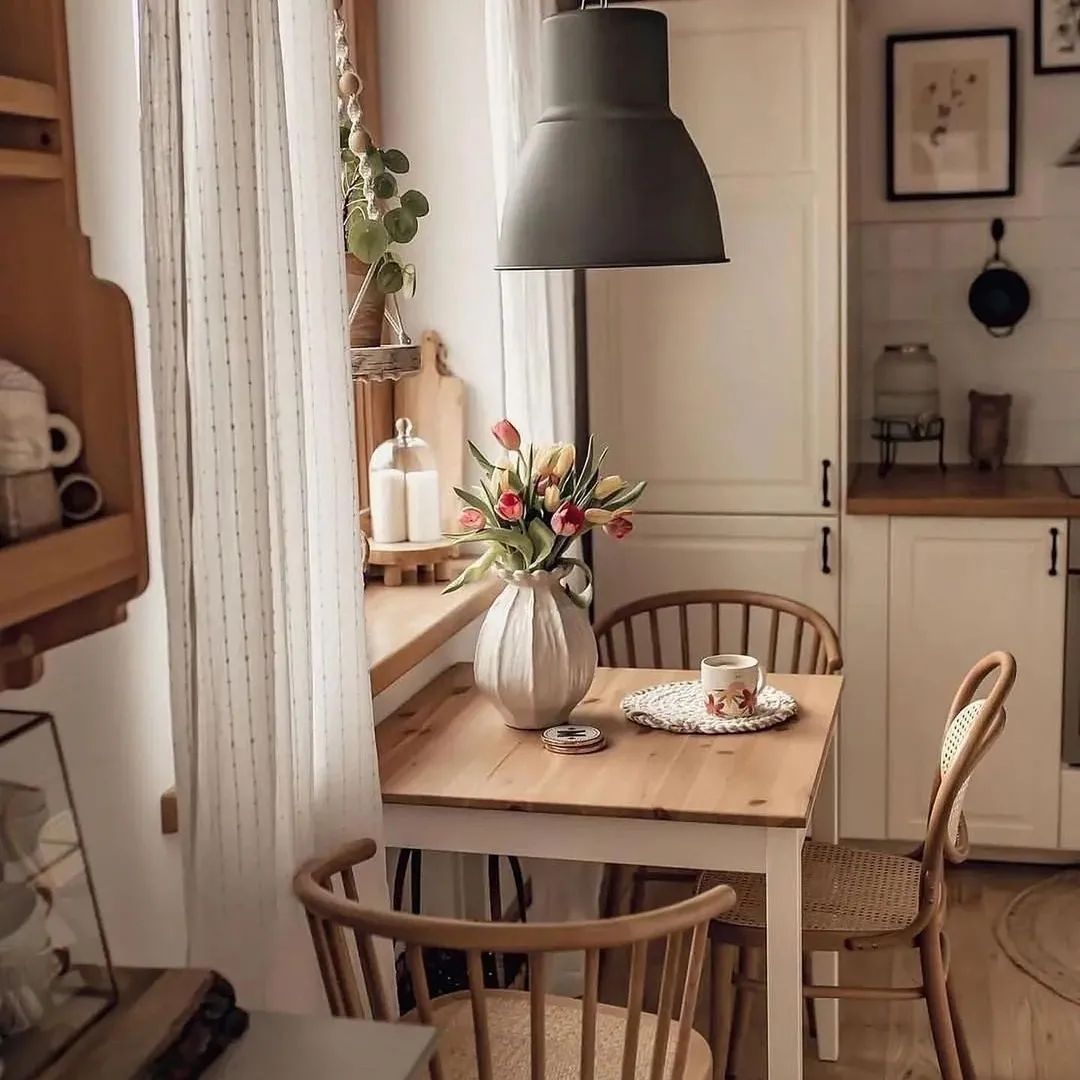 Cozy kitchen nook with a small wooden table and fresh tulips