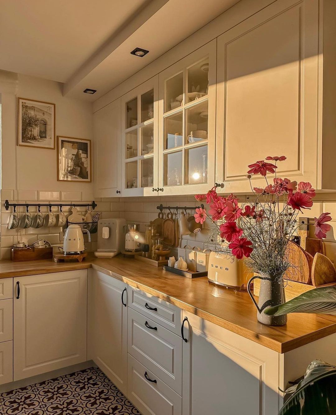 A warm, inviting kitchen basking in golden sunlight featuring wooden countertops and classic cabinetry