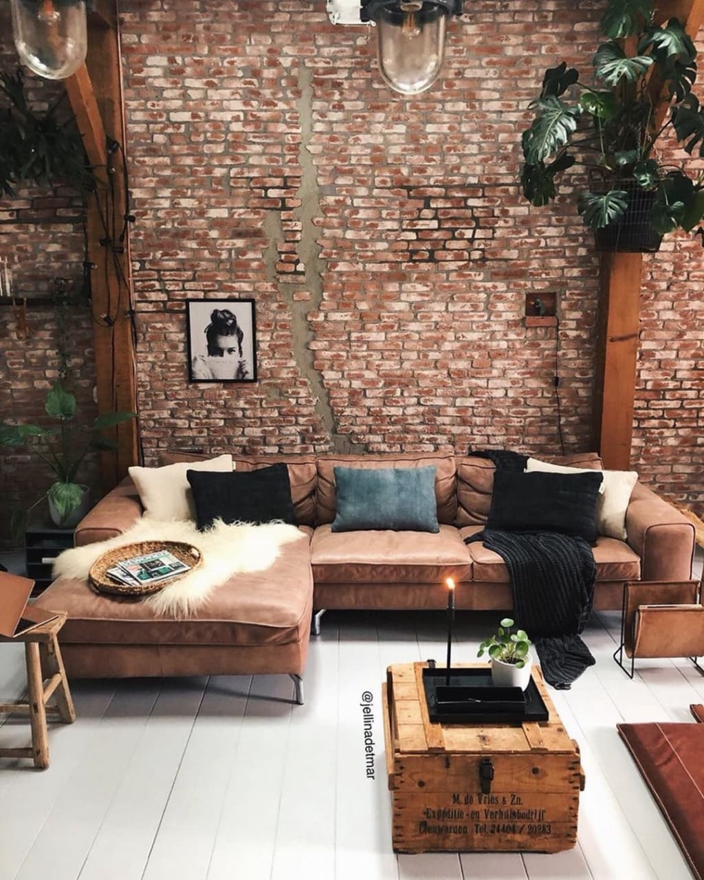 A cozy living room with exposed brick walls and a comfortable leather sectional