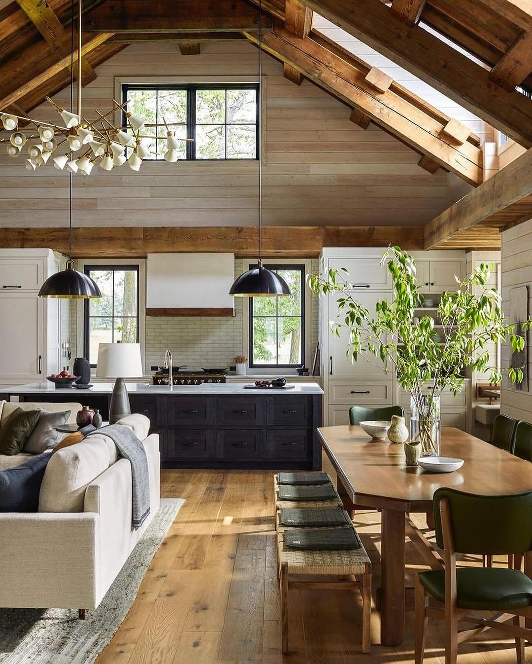 A cozy and modern kitchen-living space with exposed wooden beams