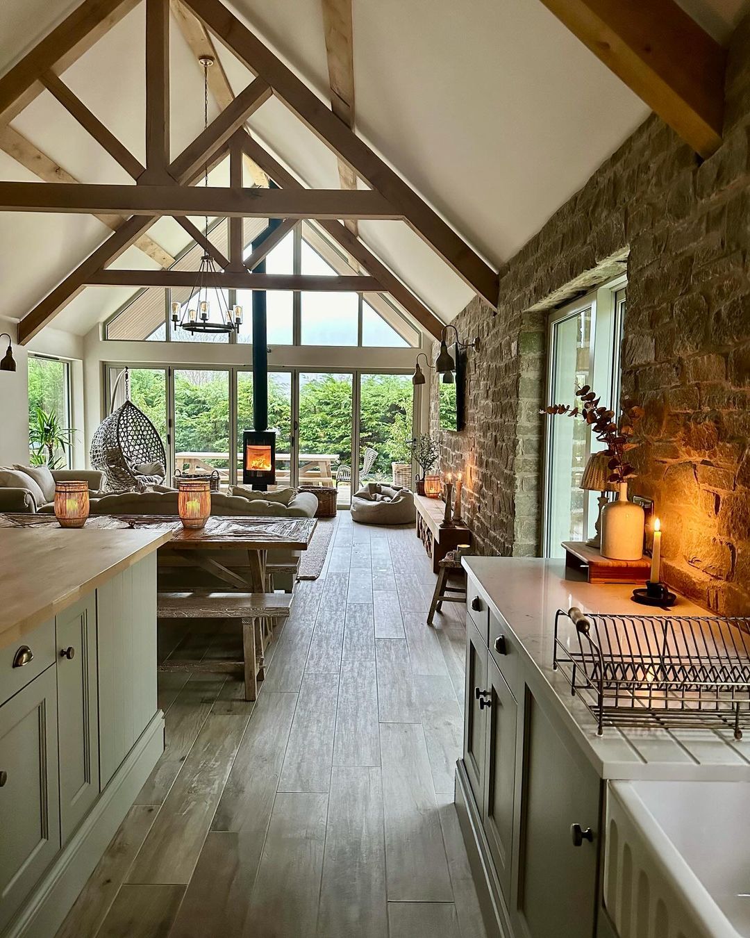 A cozy yet modern kitchen showcasing exposed stone walls and a vaulted ceiling with wooden beams