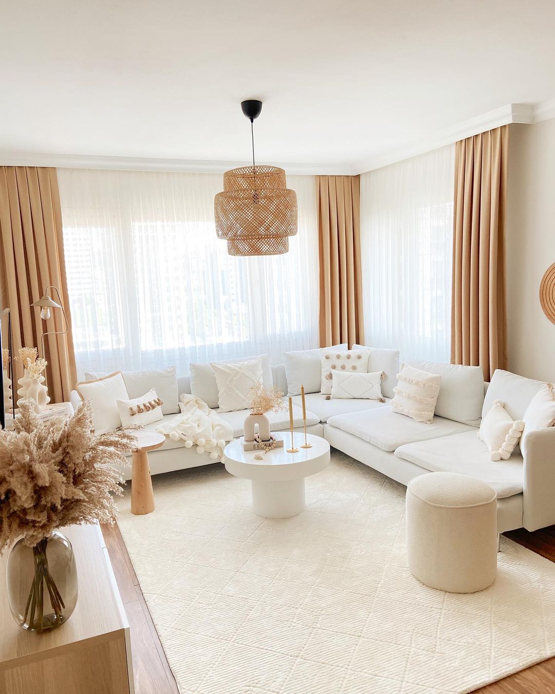 A calming monochrome living room design featuring an organic wicker pendant lamp