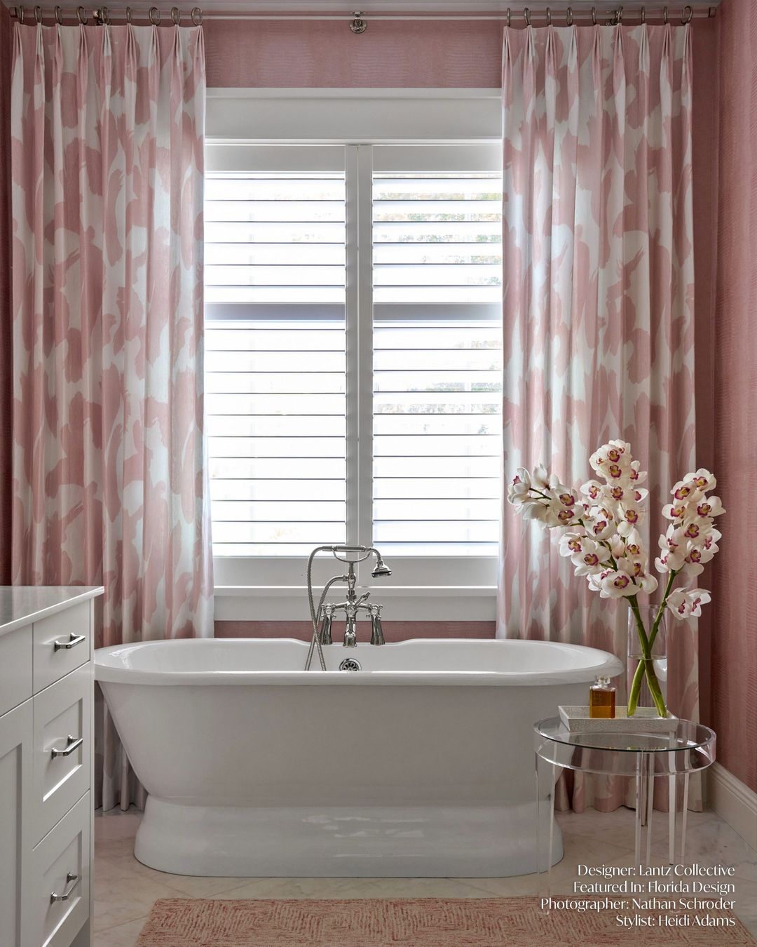 A cozy pink-toned bathroom featuring a free-standing white tub