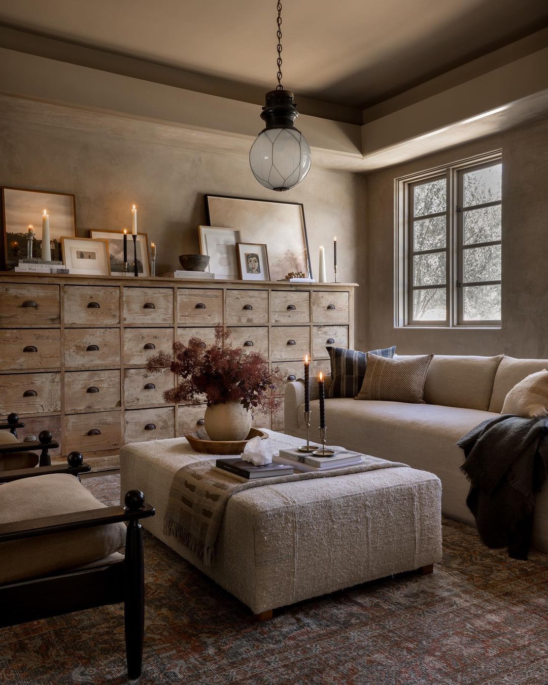 A cozy and inviting reading nook featuring a plush beige sofa and textured ottomans