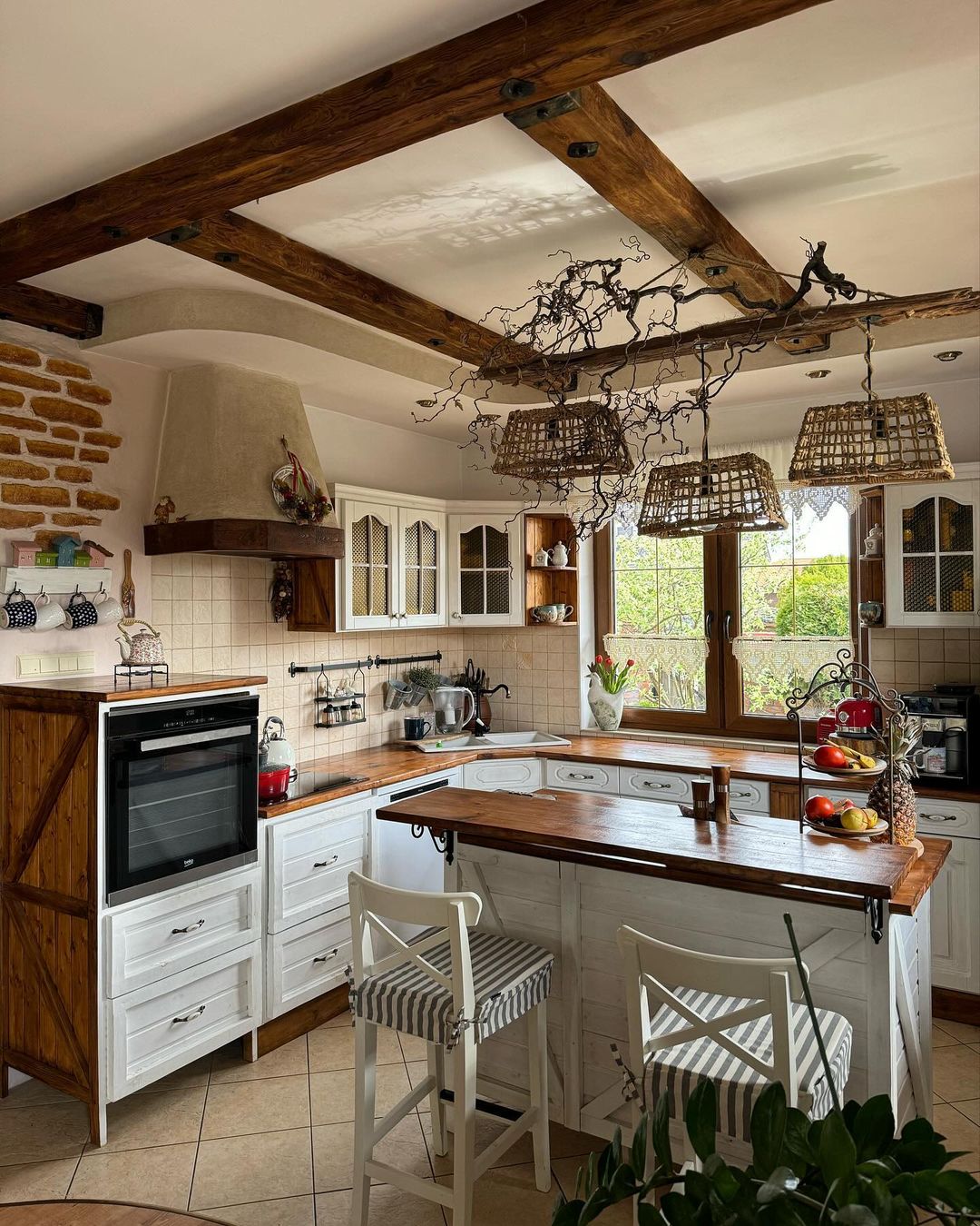 A cozy and rustic kitchen with exposed beams and a central island.