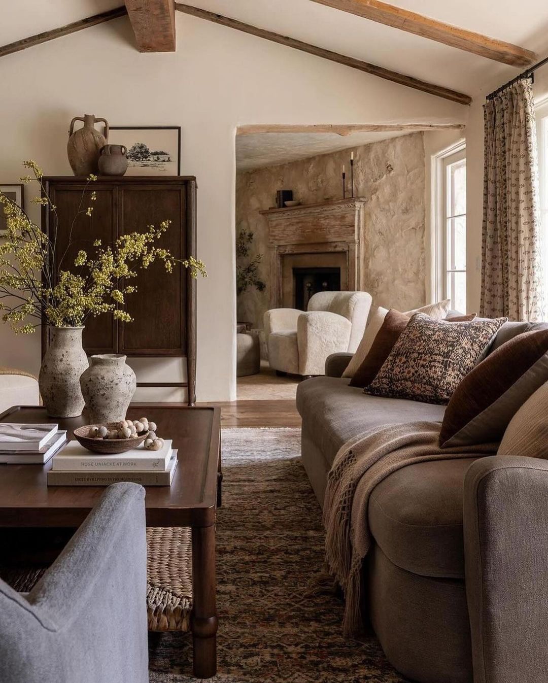 A cozy and rustic living room featuring exposed wooden beams