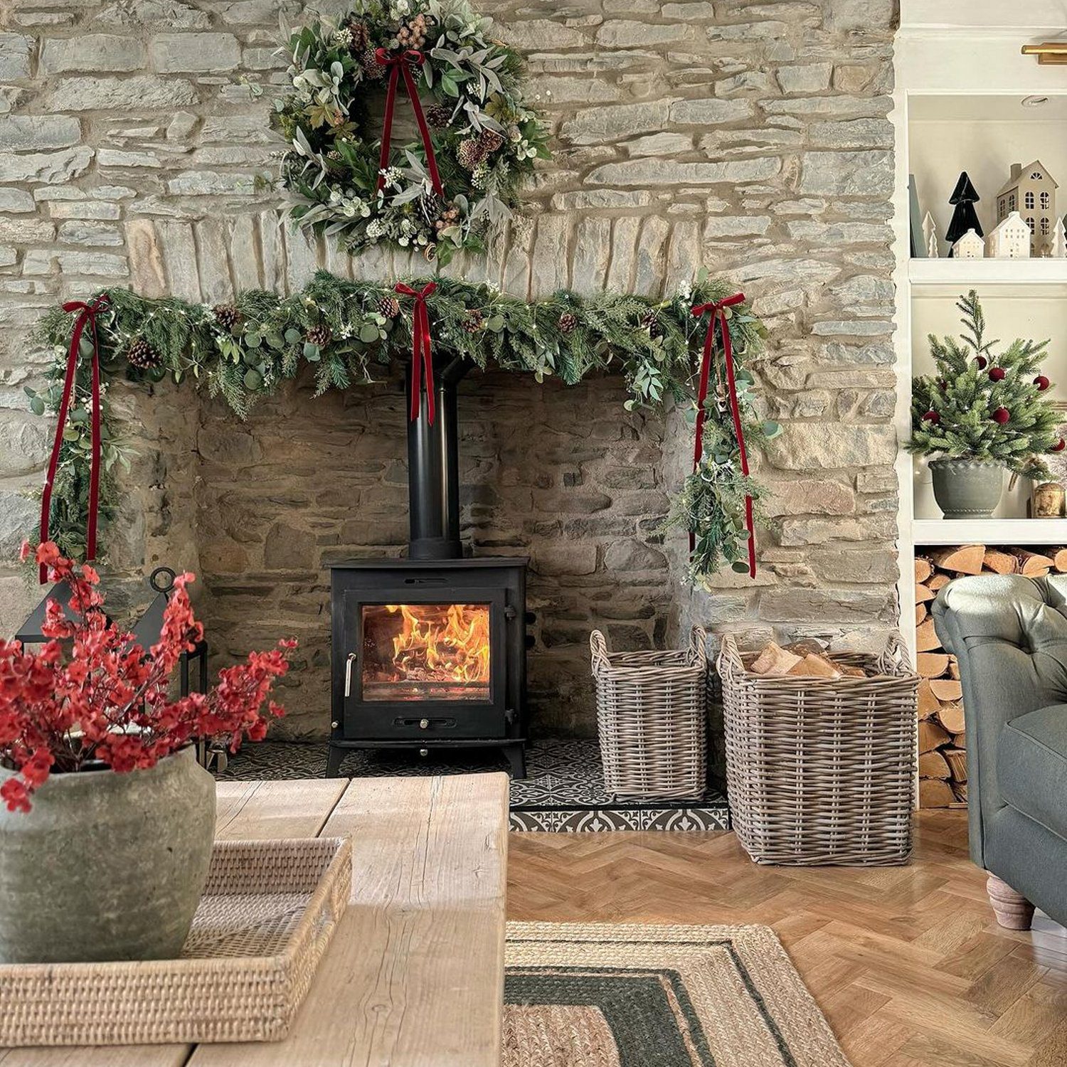 A cozy and inviting room featuring a stone fireplace with festive decorations