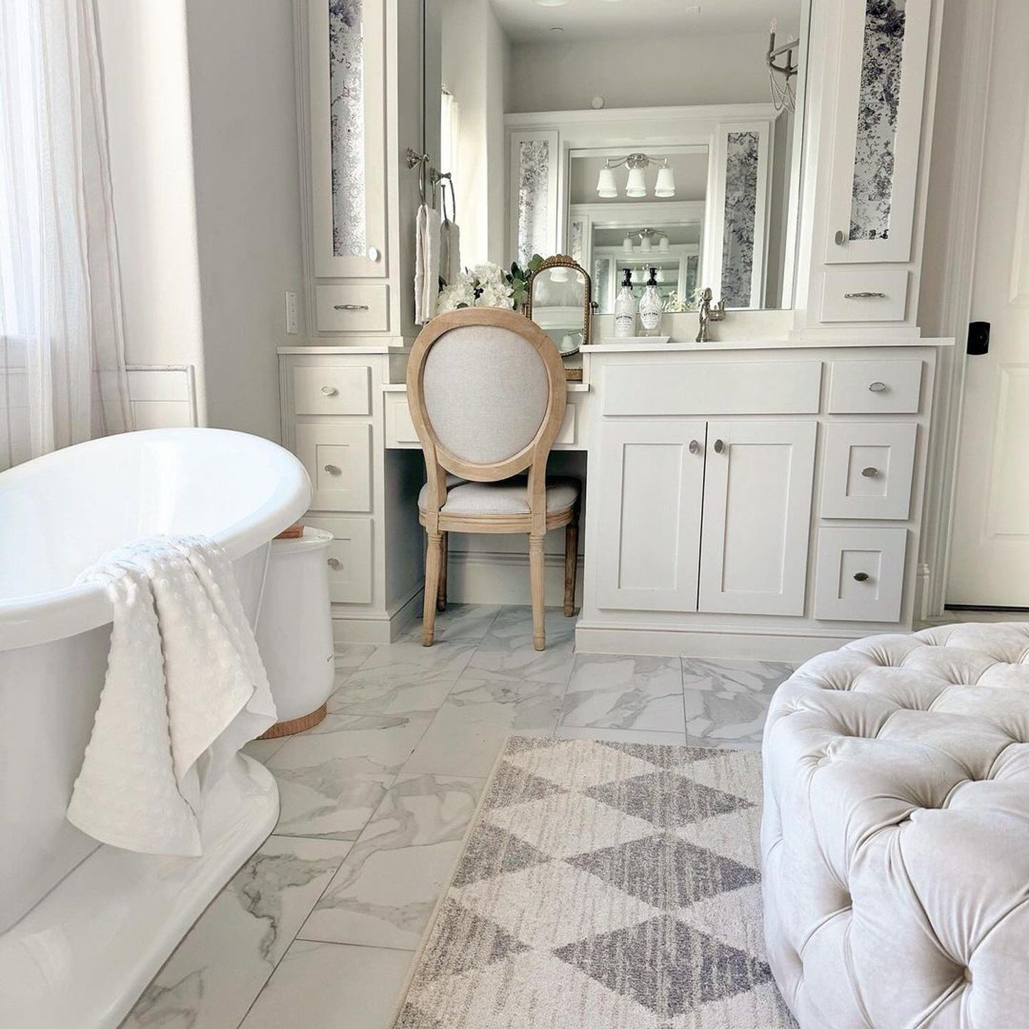 Elegant white bathroom with decorative floor tiles and a free-standing tub