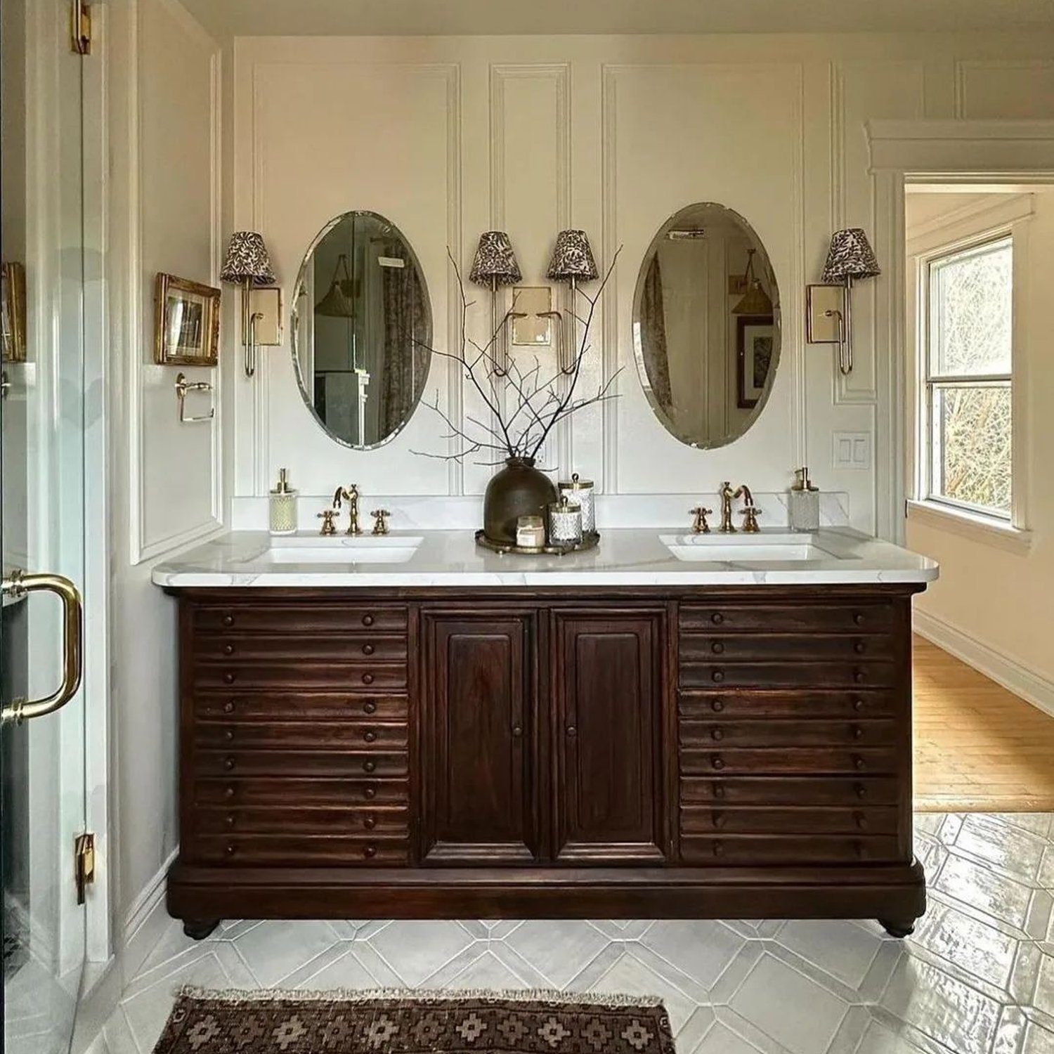 Elegant brown and white bathroom with twin round mirrors