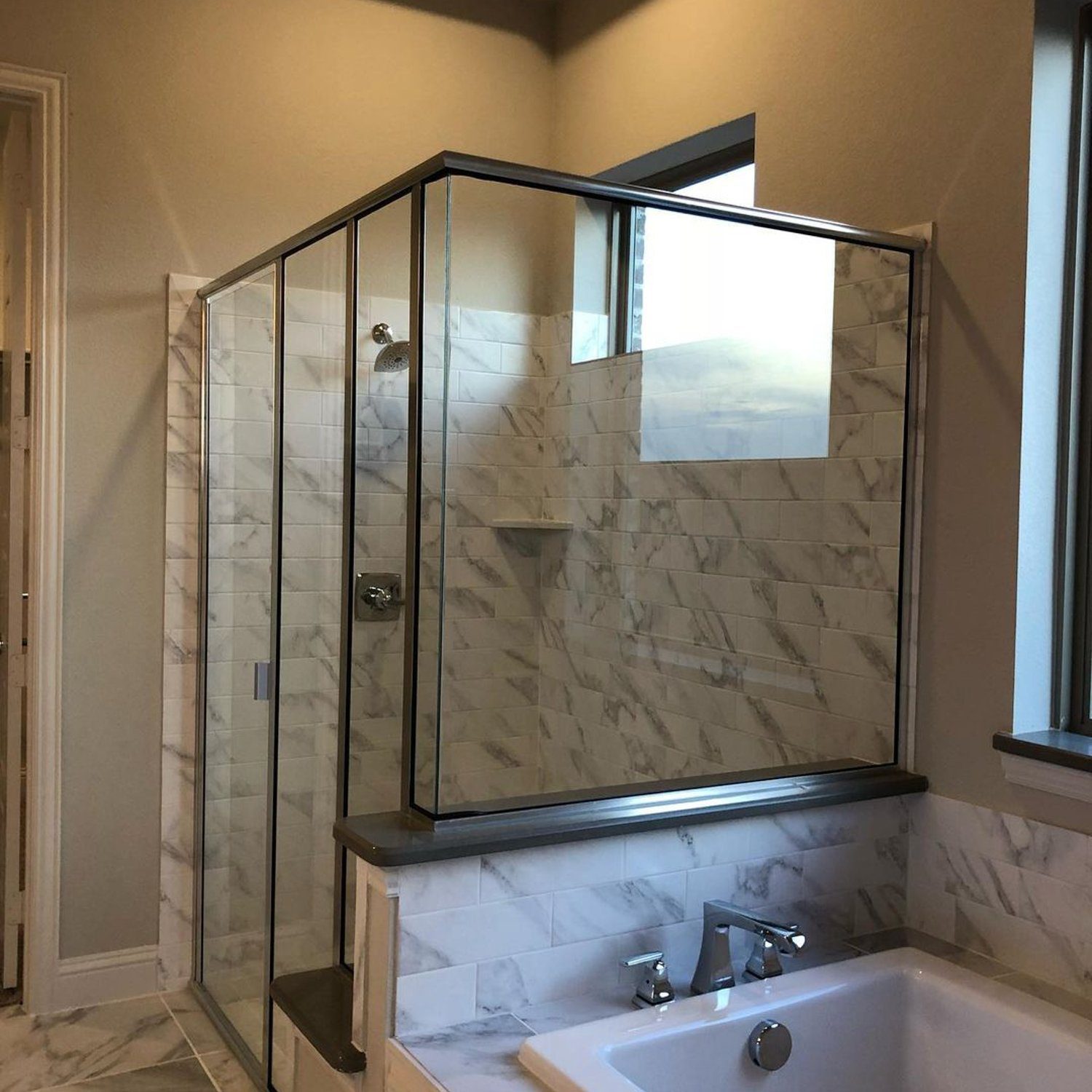 Elegant marble-tiled bathroom with a spacious shower cabin