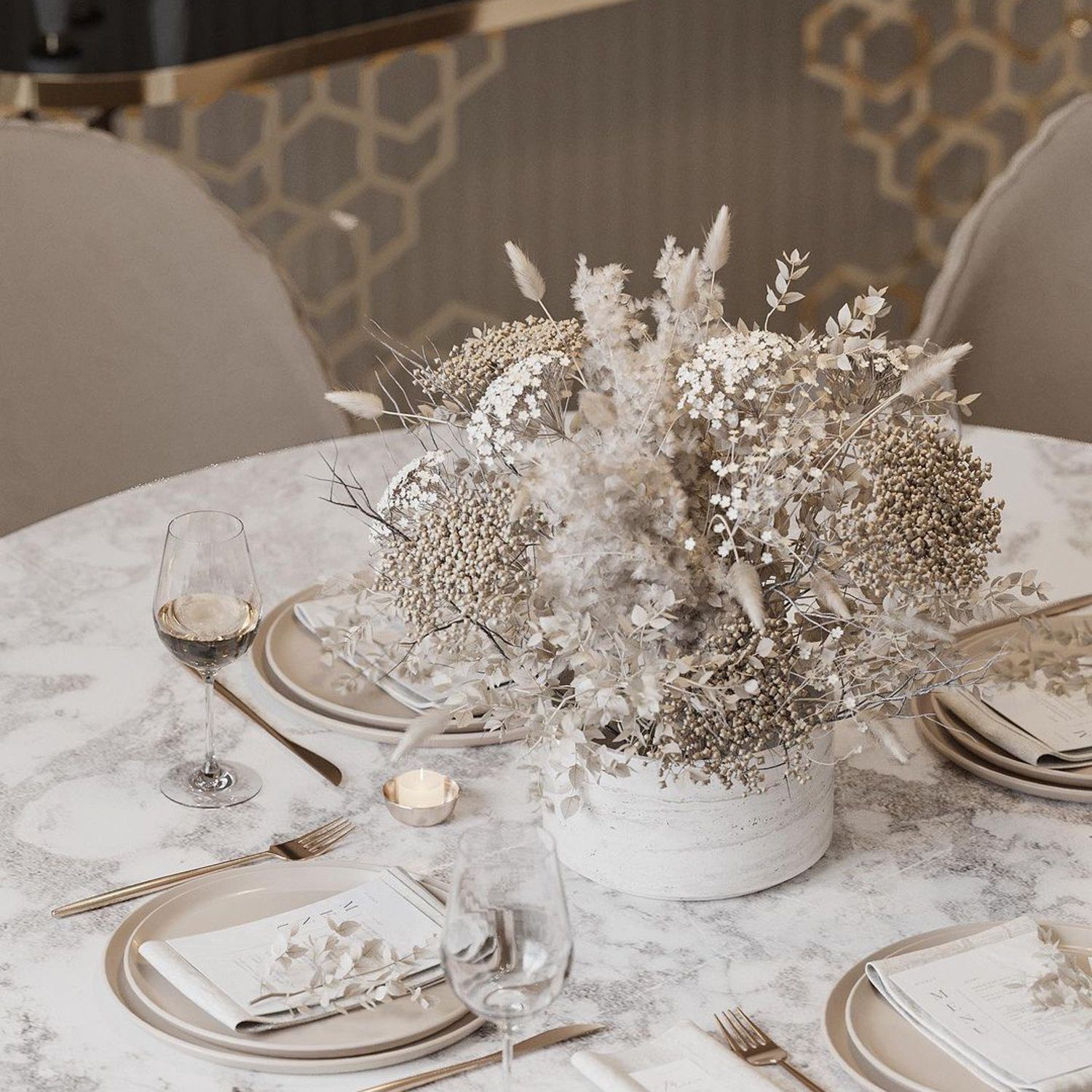 Elegantly set table with dried floral centerpiece in a modern dining room