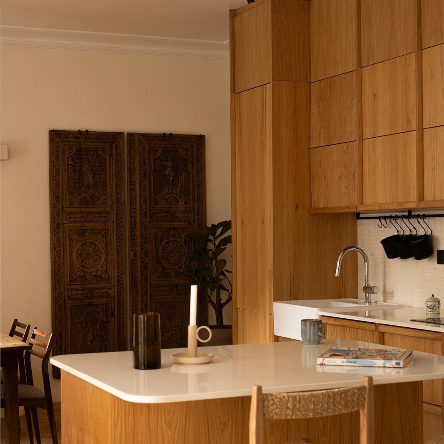 A minimalistic kitchen space with wood cabinetry and a stylish central island.