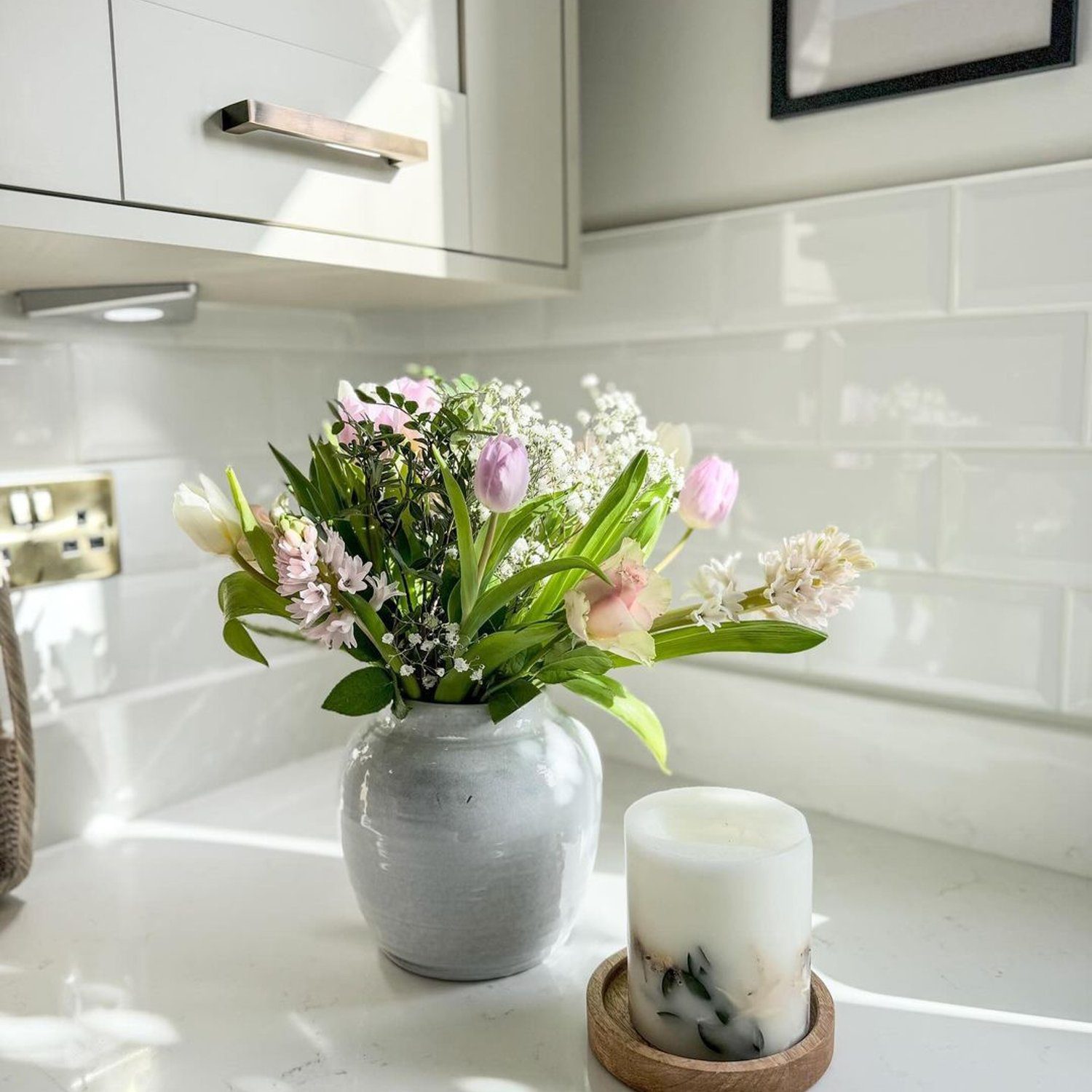 A contemporary kitchen accentuated with a bouquet of fresh flowers and a decorative candle