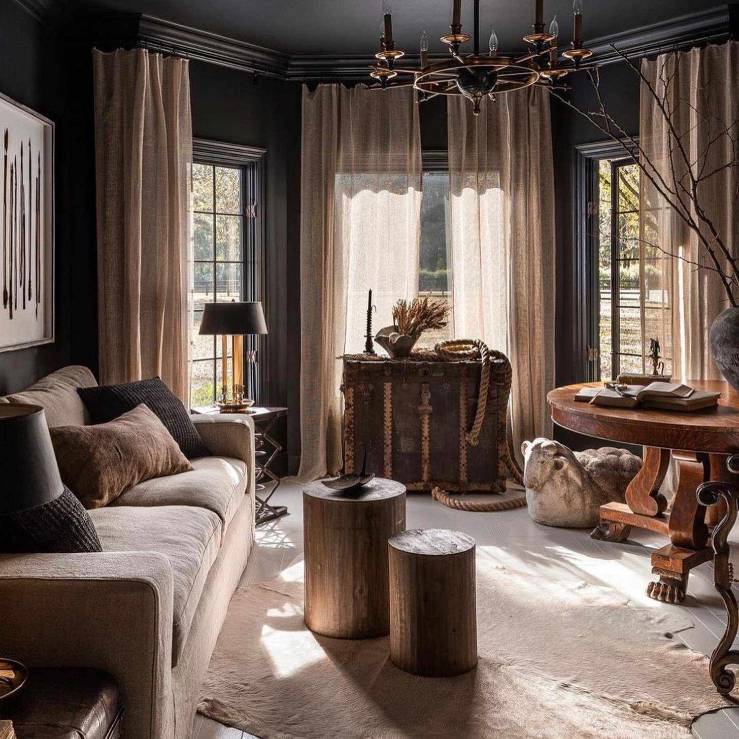 A tastefully decorated living room featuring dark walls and natural materials