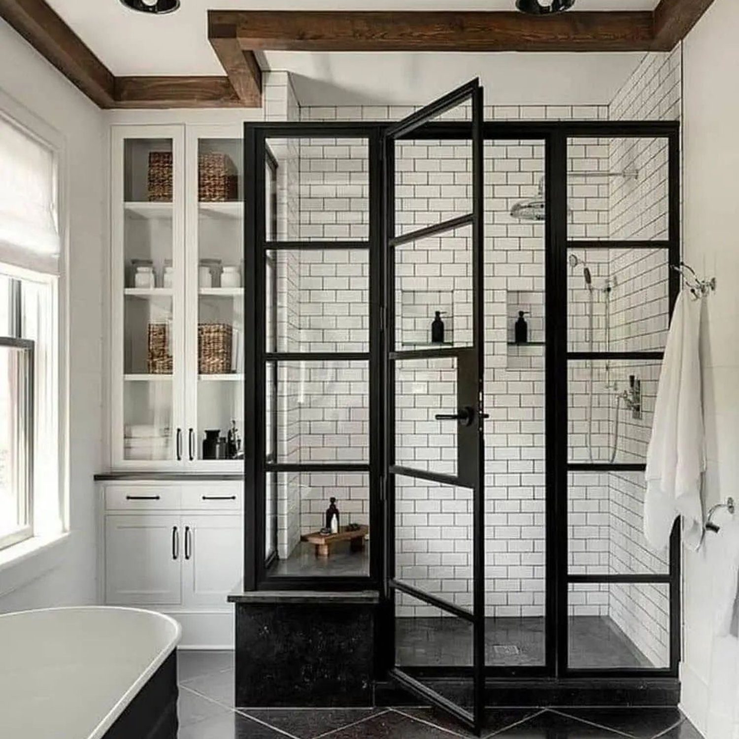 Elegant modern bathroom with a freestanding tub and industrial-style glass shower enclosure