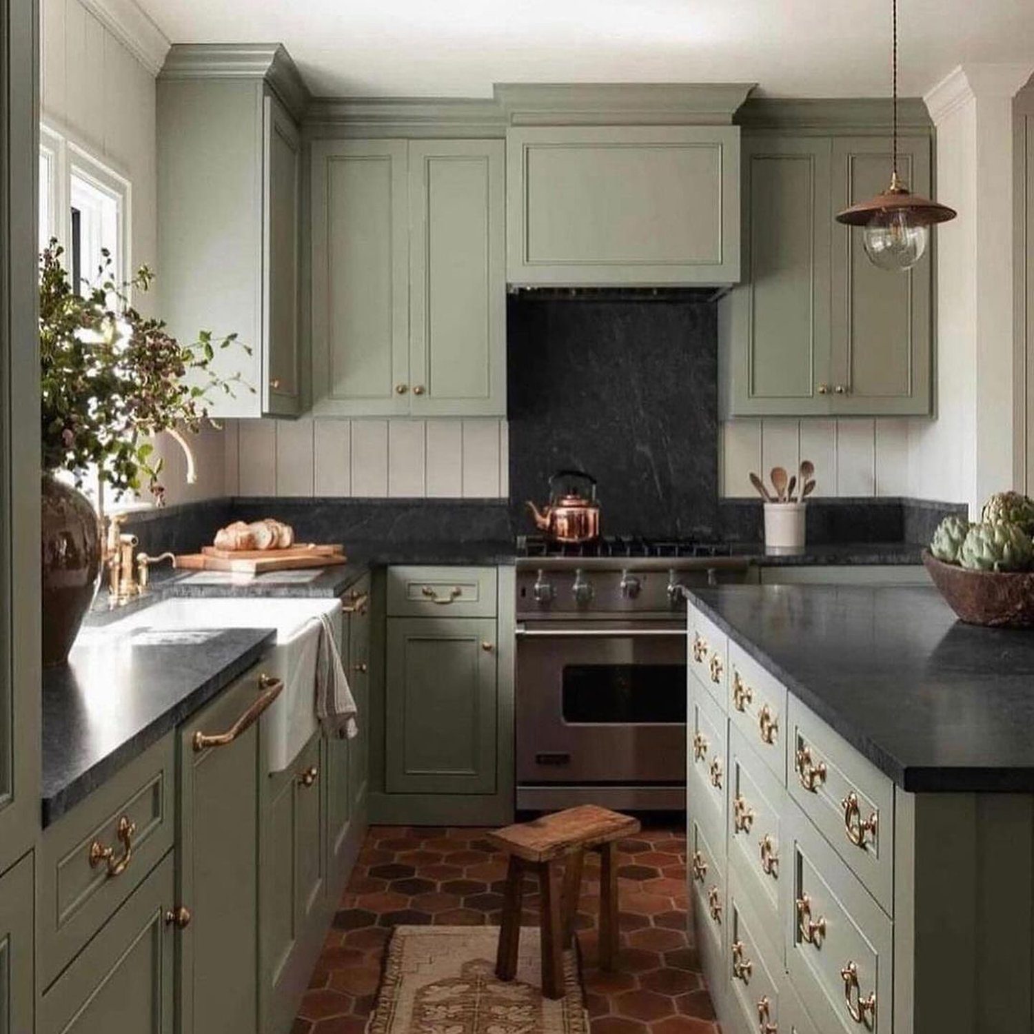 A tastefully designed kitchen featuring sage green cabinetry