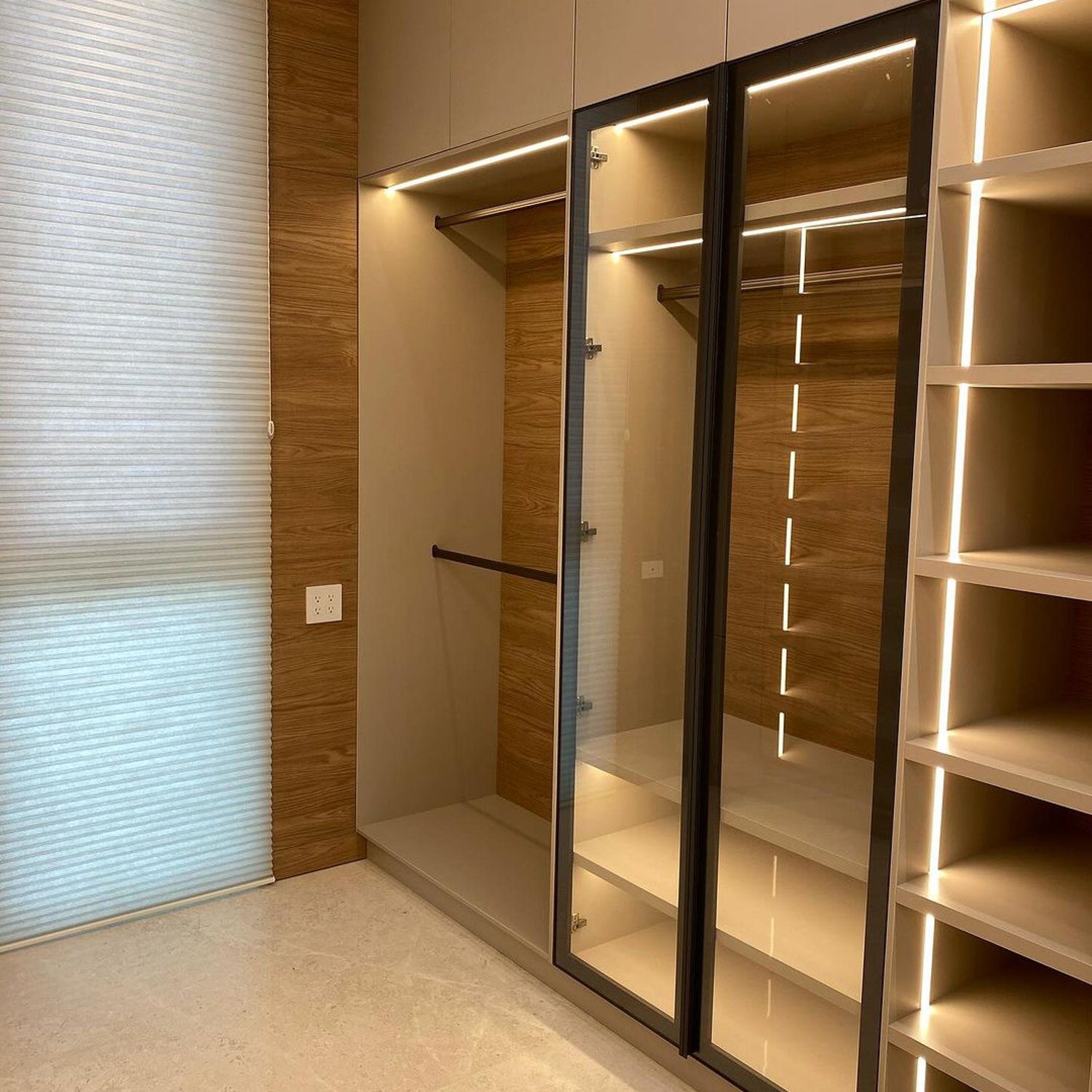 Elegant walk-in closet featuring a minimalist design with wood accents and integrated LED lighting