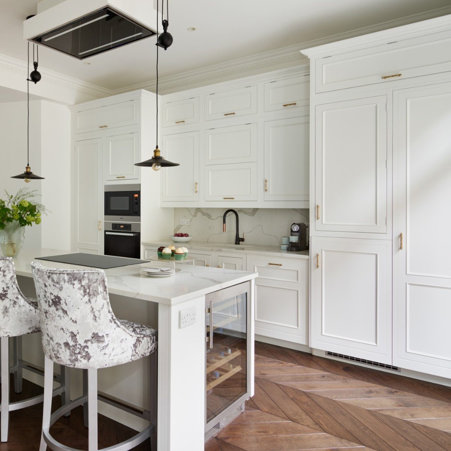 Elegant white kitchen with herringbone wood floor