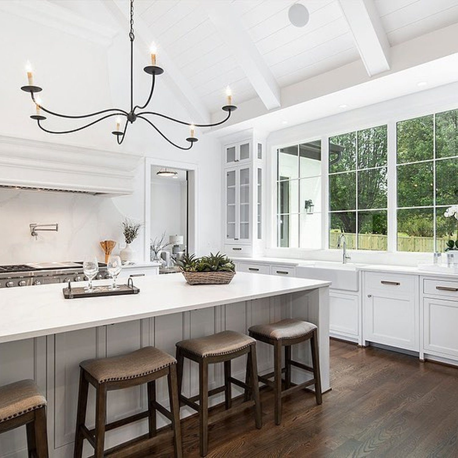 Elegant white kitchen featuring high ceilings and modern fixtures