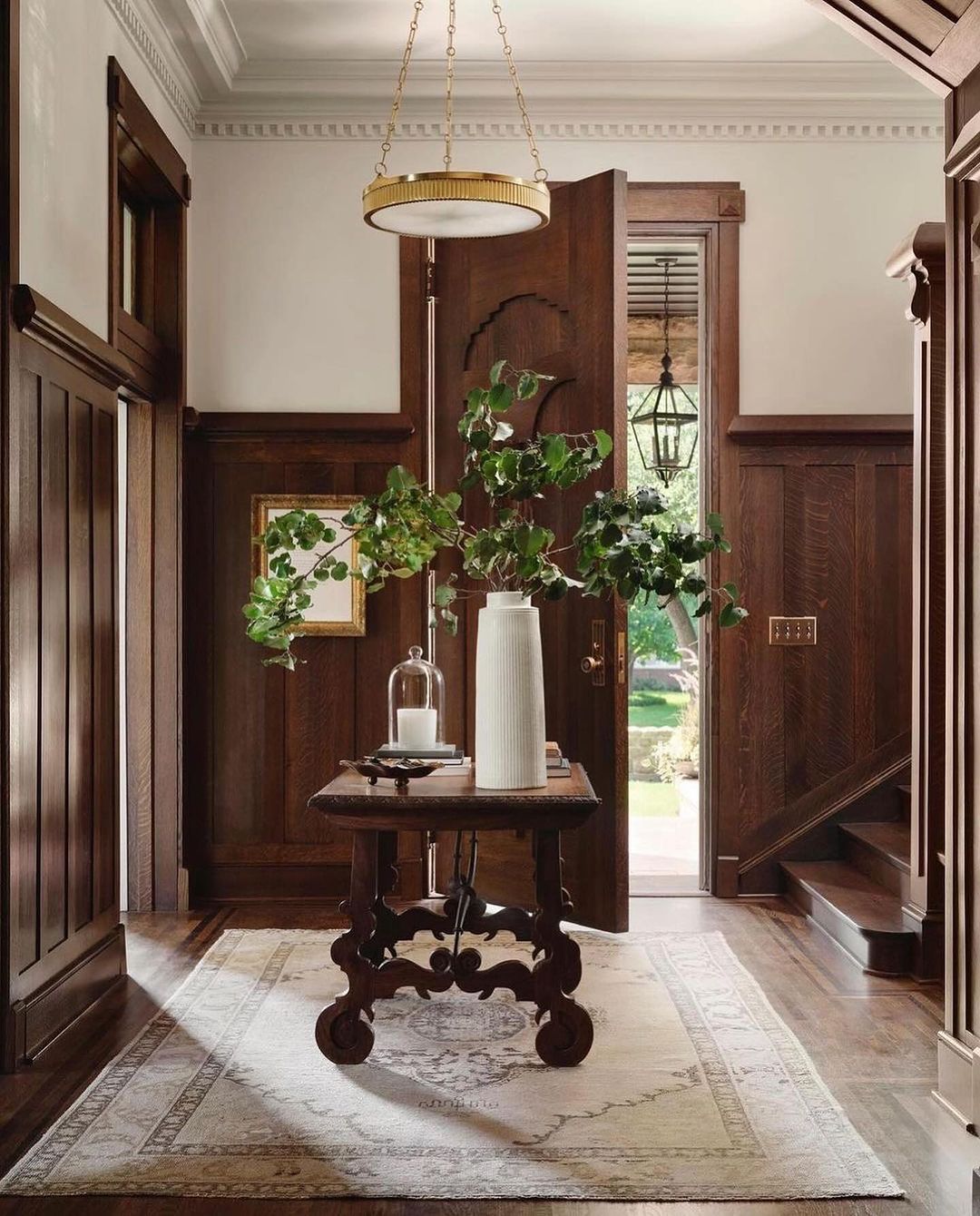 A classic entryway featuring dark wood paneling and a vintage-style wooden table