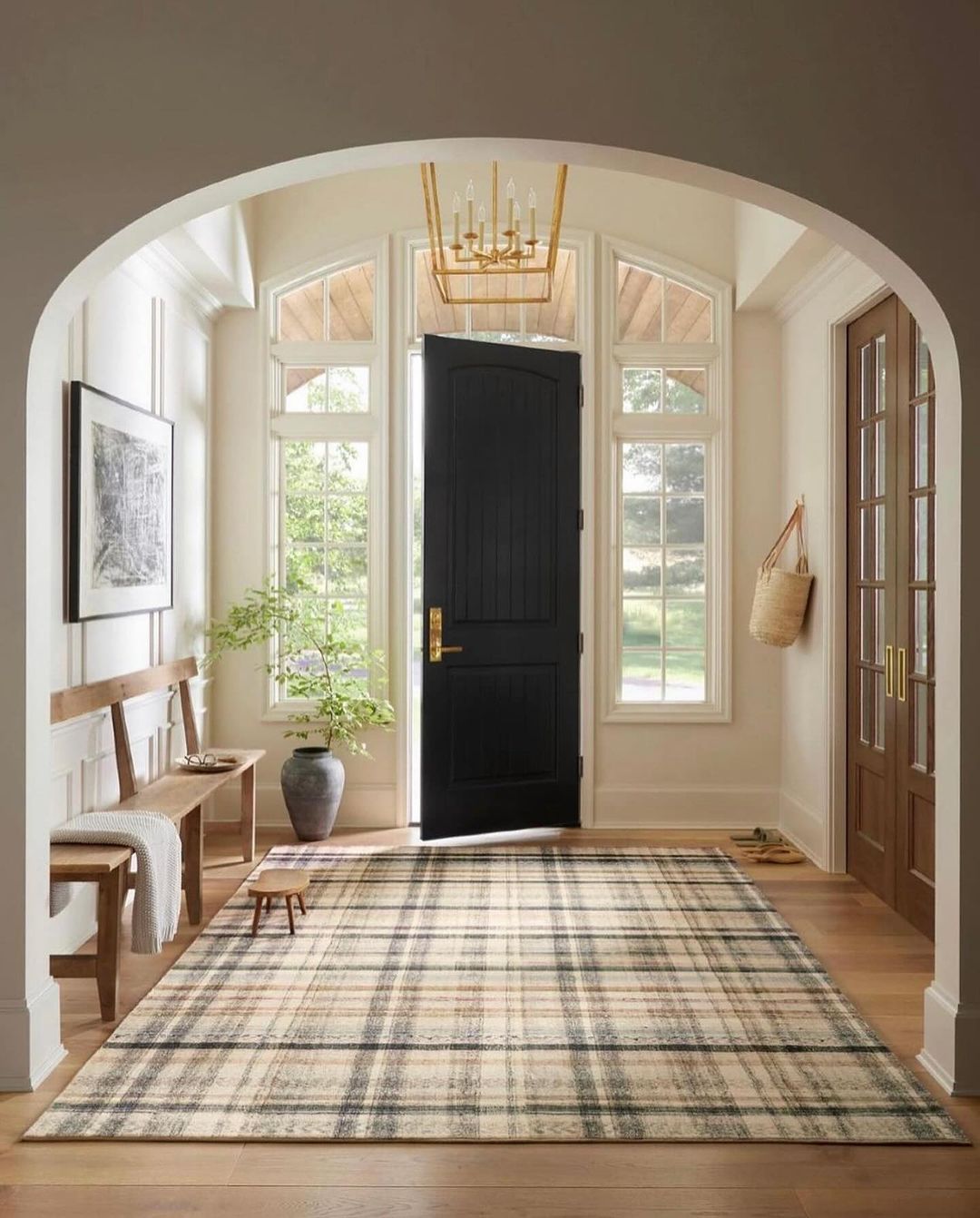 A welcoming entryway featuring a dark wood bench and a subtle plaid rug