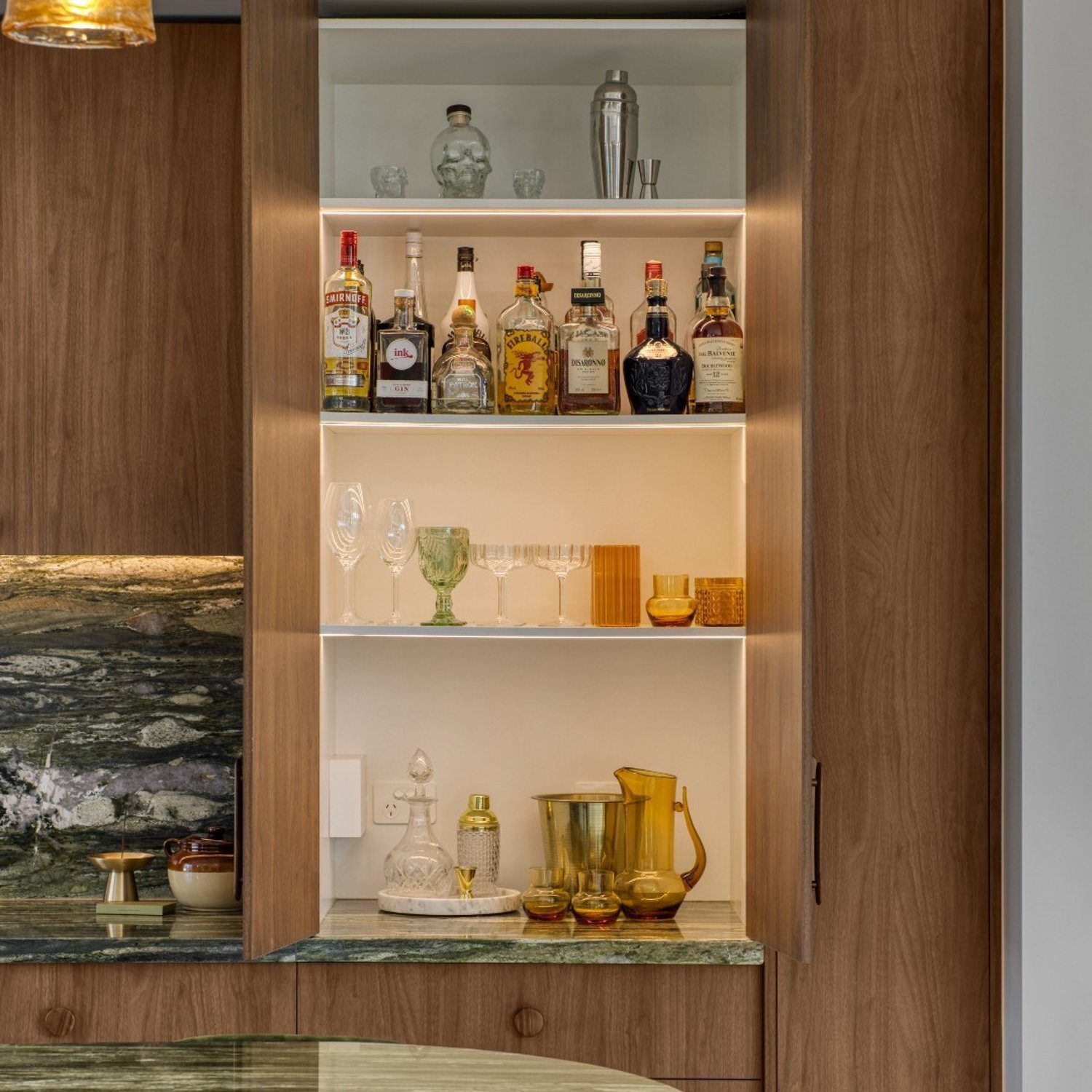 Elegantly arranged home bar with a selection of spirits and stylish glassware