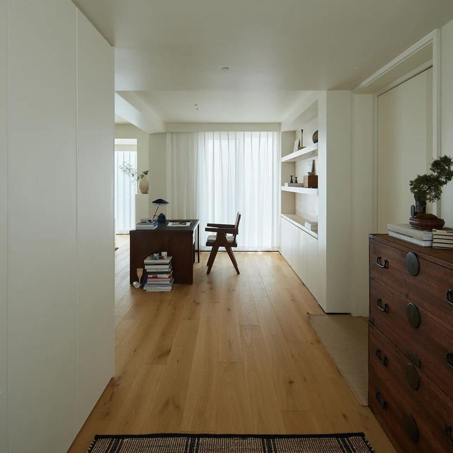 A minimalist home office with warm wooden floors